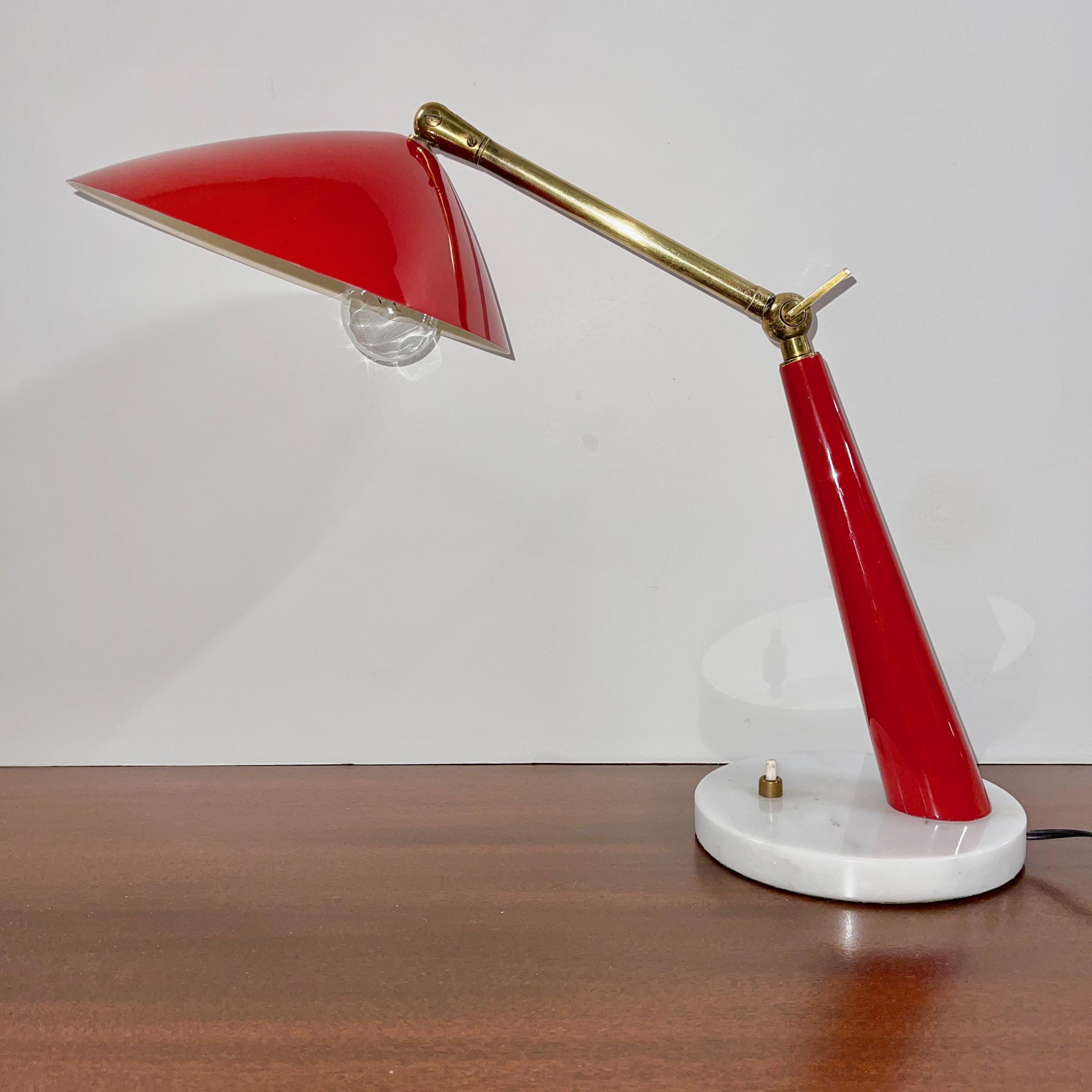 1950's Italian articulating desk lamp designed by Oscar Torlasco for Stilux Milano. 
Round white marble base, bright red enamel shaft and distinctive shade and brass armature, key adjustable elbow connector and articulating swivel joint. 
Remnants