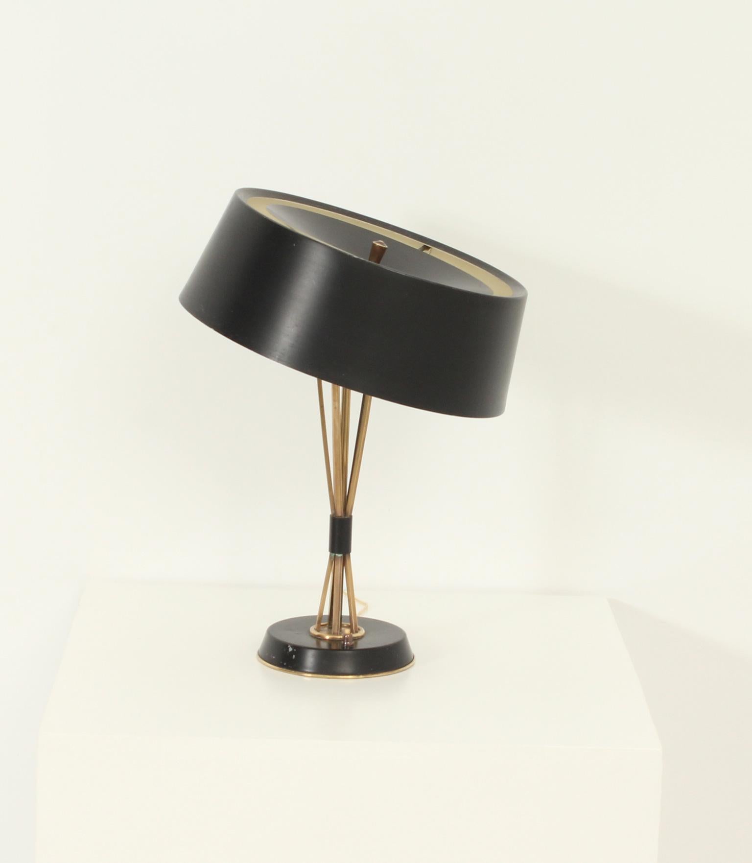 Large table lamp designed by Oscar Torlasco for Lumi, Italy 1960's. Adjustable shade that can take different positions. Shade and base in black lacquered aluminum and brass stem and details.