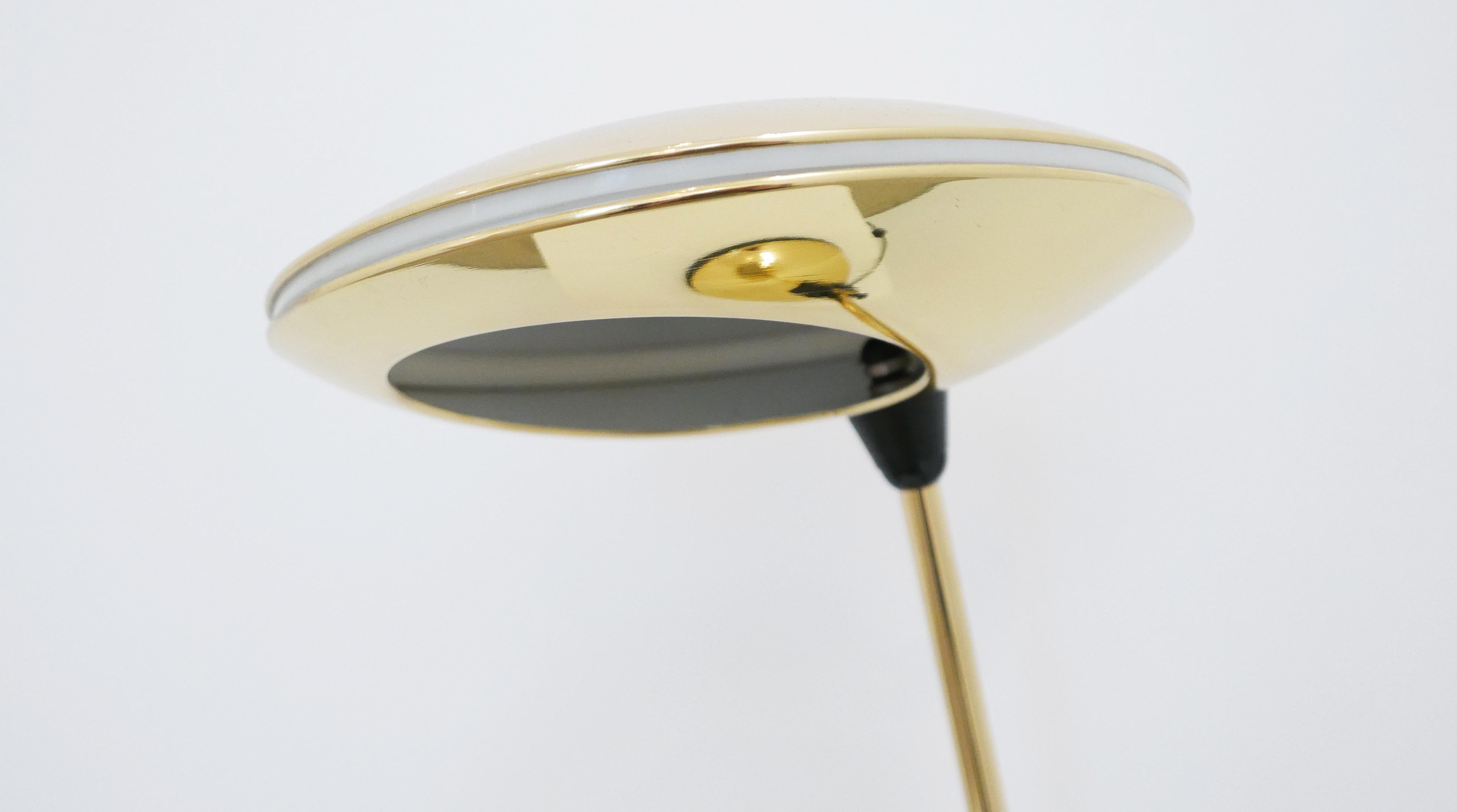 Brass-plated steel, plastic and frosted glass
Measures: 21.5 H x 20 W x 12.5 D inches
Meticulously restored and in excellent condition

Domed base holds a cylindrical shaft with adjustable inclination. Disc lamp shade features beautiful cut-out