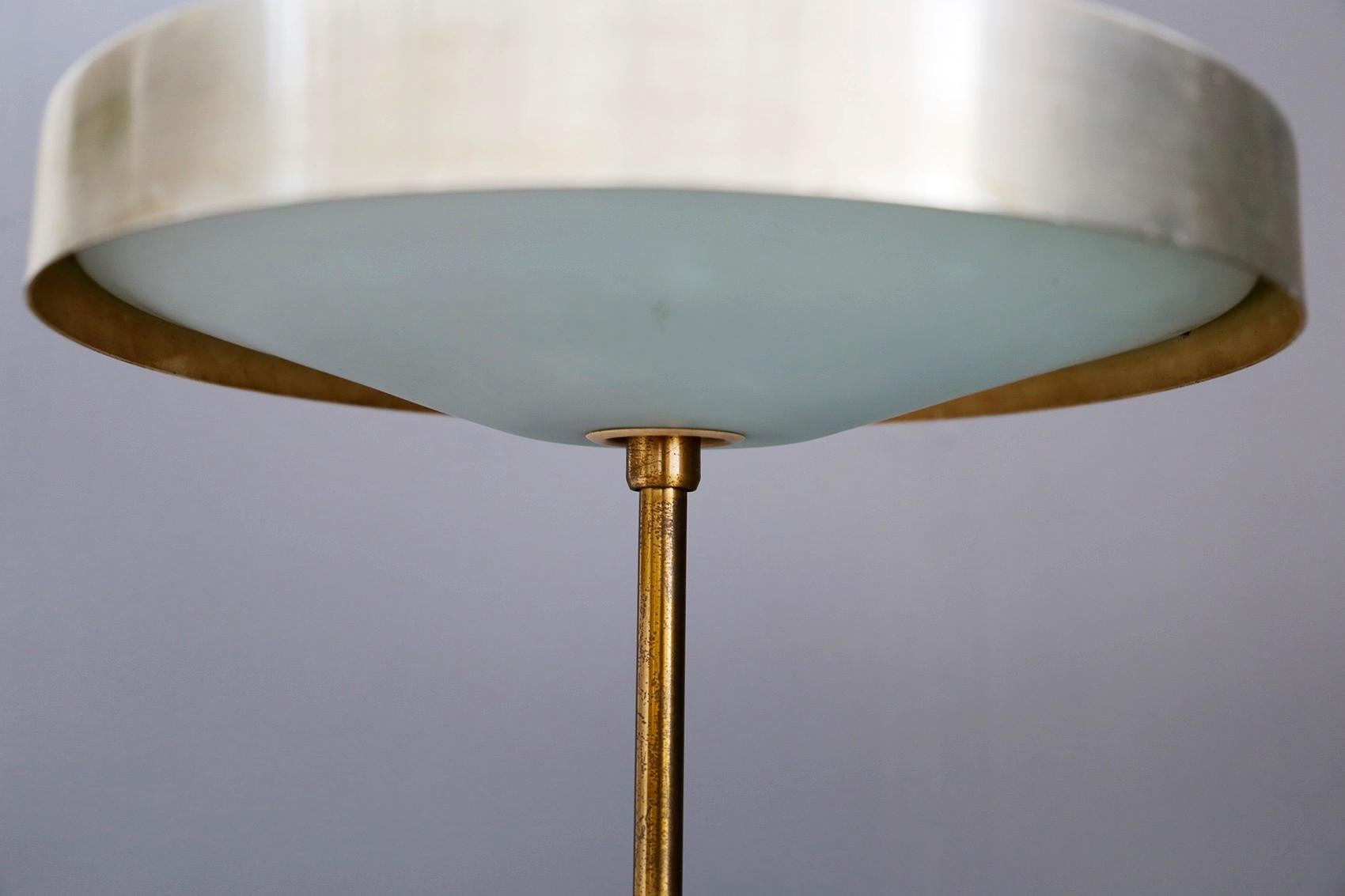 Rare table lamp created by Oscar Torlasco for Lumi in 1950. The lamp was published in Domus, a furniture magazine. Its particularity is its semi-spherical light holder, almost reminiscent of a UFO shape. The structure and base is in brass. Note the