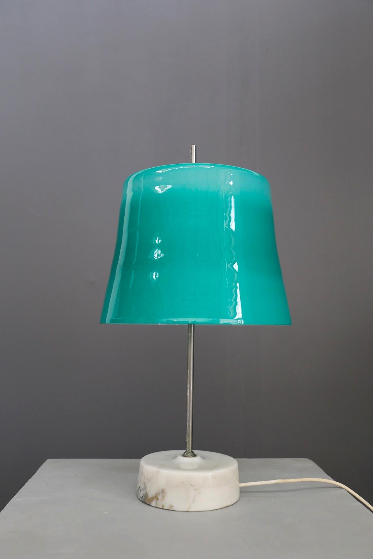 Rare table lamp designed by Oscar Torlasco in 1960. The lamp is in excellent condition. Its base is in circular turned white marble. Its structure is in painted aluminum. While his hat is made of glass lined with water green color. The lamp has