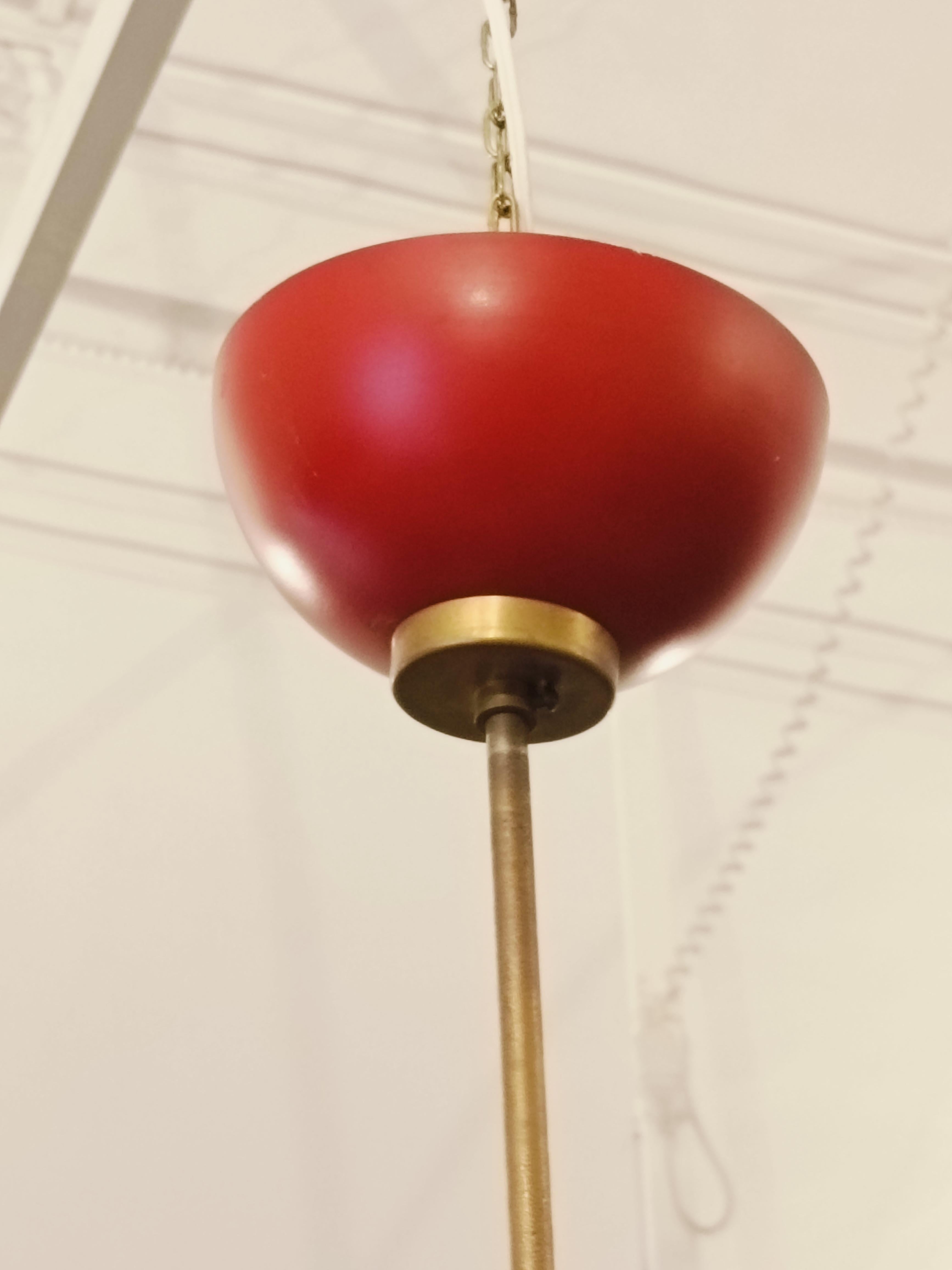 Rarissimo Lampadario Modello 553 di Oscar Torlasco per Lumi anni '60 circa.
Grande sfera in metallo rosso smaltato con anello diagonale in ottone. Il lampadario ha 24  lampadine con alloggio incavato nella sfera e circondato da un piccolo anello in