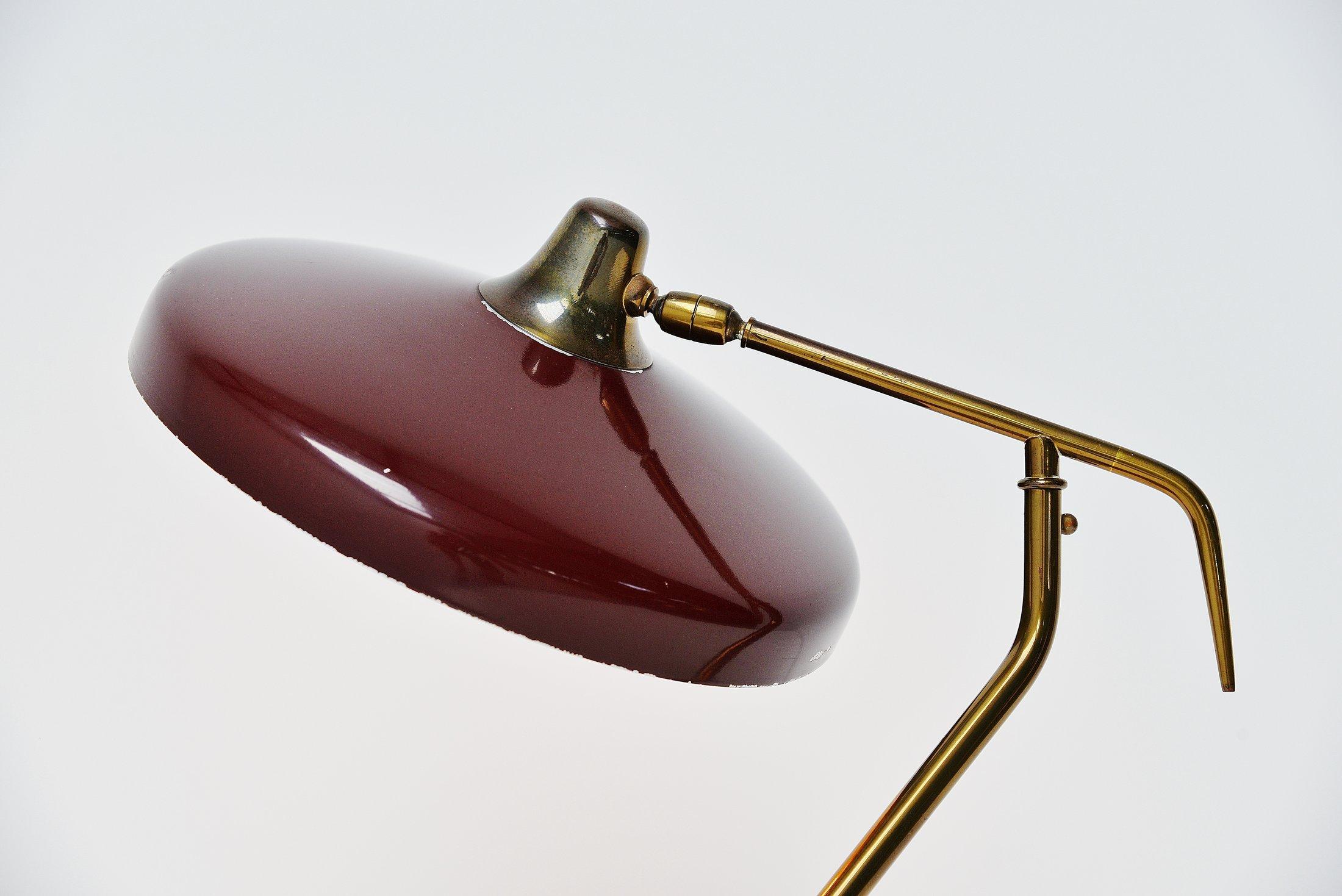 Very nice sculptural table lamp designed by Oscar Torlasco and manufactured by Lumi, Italy, 1950. This lamp has a very nice chic Bordeaux red lacquer finish and the rest is made of brass. The lamp has a nice patina from age and usage and is