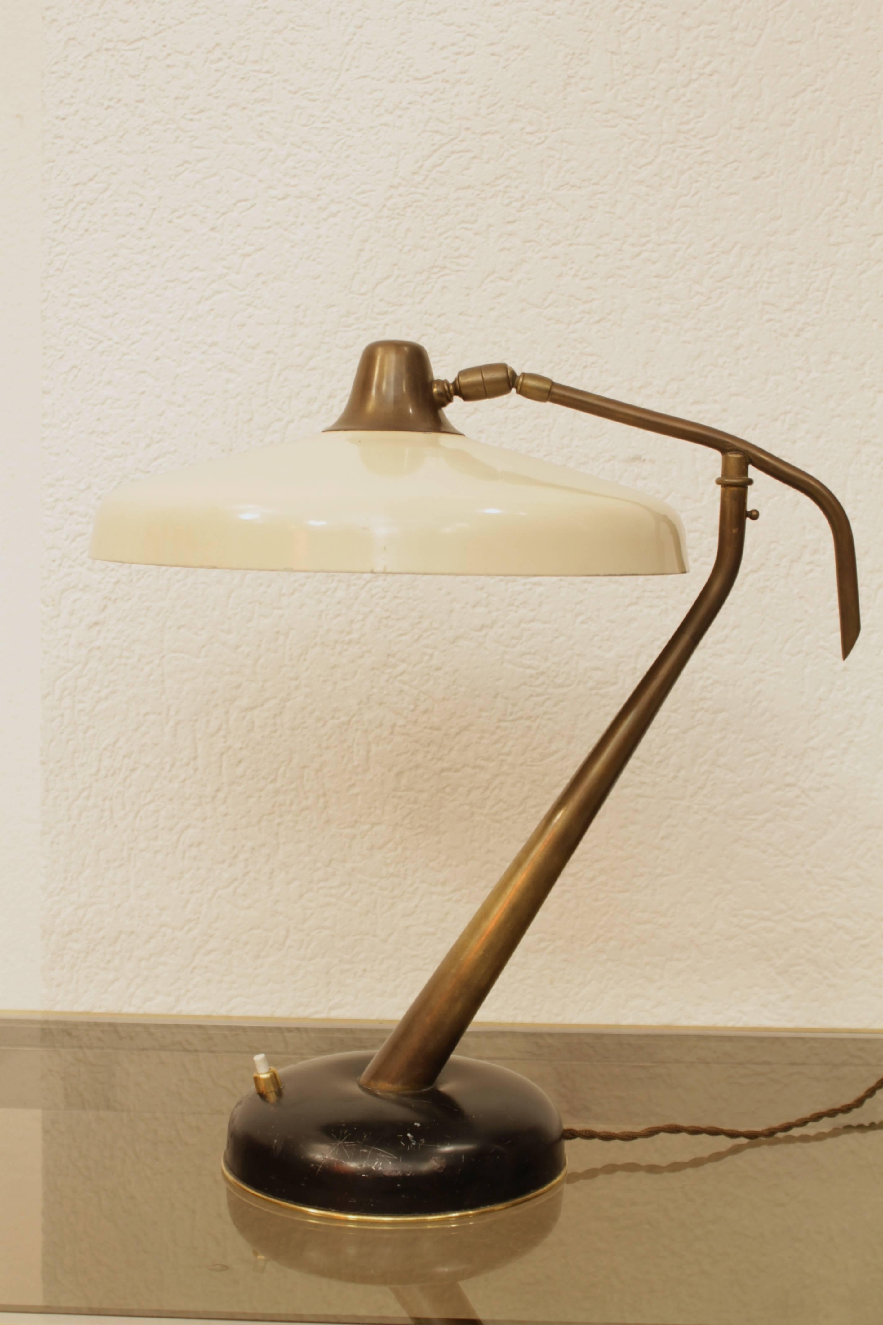 Rare brass and off white metal table or desk lamp by Oscar Torlasco for Lumi, Italy, circa 1950s
Original condition, unrestored, patinated brass
Multiple position, swivelling
Bump on the metal base.
   