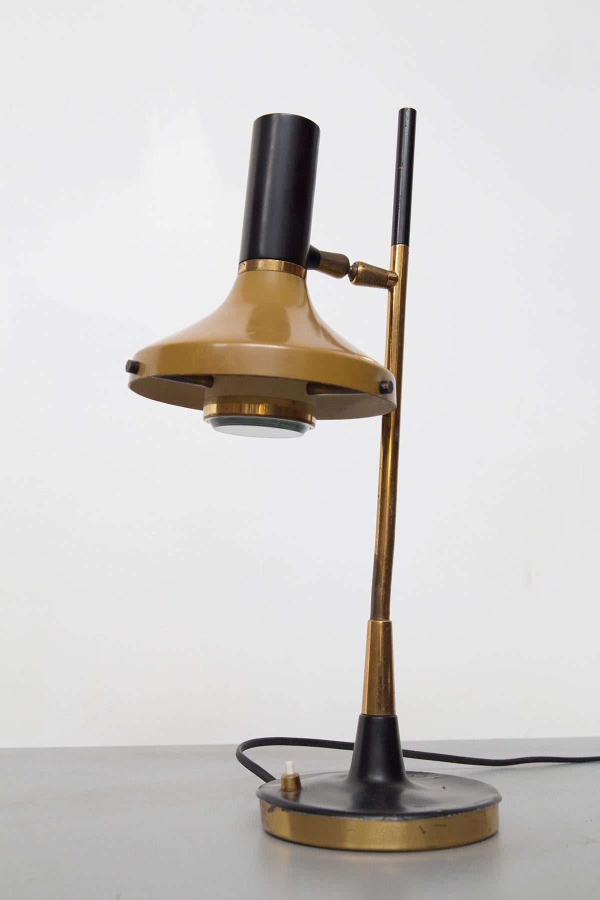 Fantastic vintage table lamp model 533 designed by the great Oscar Torlasco for the fine manufacture Lumi in the 1950s.
The lamp has a round metal and brass base, very beautiful, from the center of which rises the black metal and gilt brass stem in