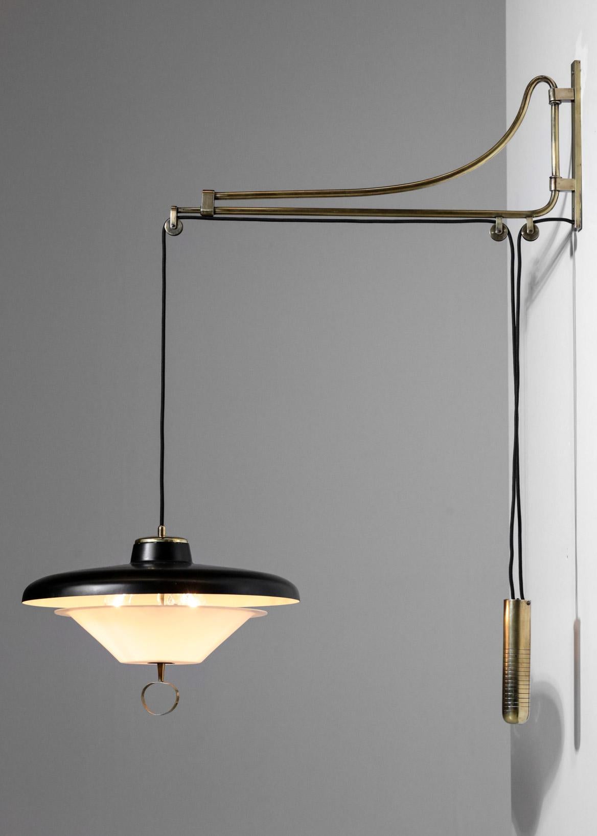 Large adjustable wall light designed by Oscar Torlasco. Made in brass with black metal shade and white plastic. Three socket for E14 bulb.