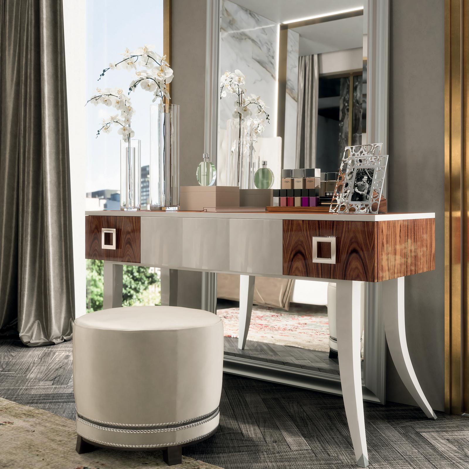 This captivating vanity table featuring 2 side drawers and 1 central drawer with push pull blumotion is a furnishing piece of refined quality. Crafted with elements in Santos rosewood, it offers a splendid polished finish and silver leaf detail for
