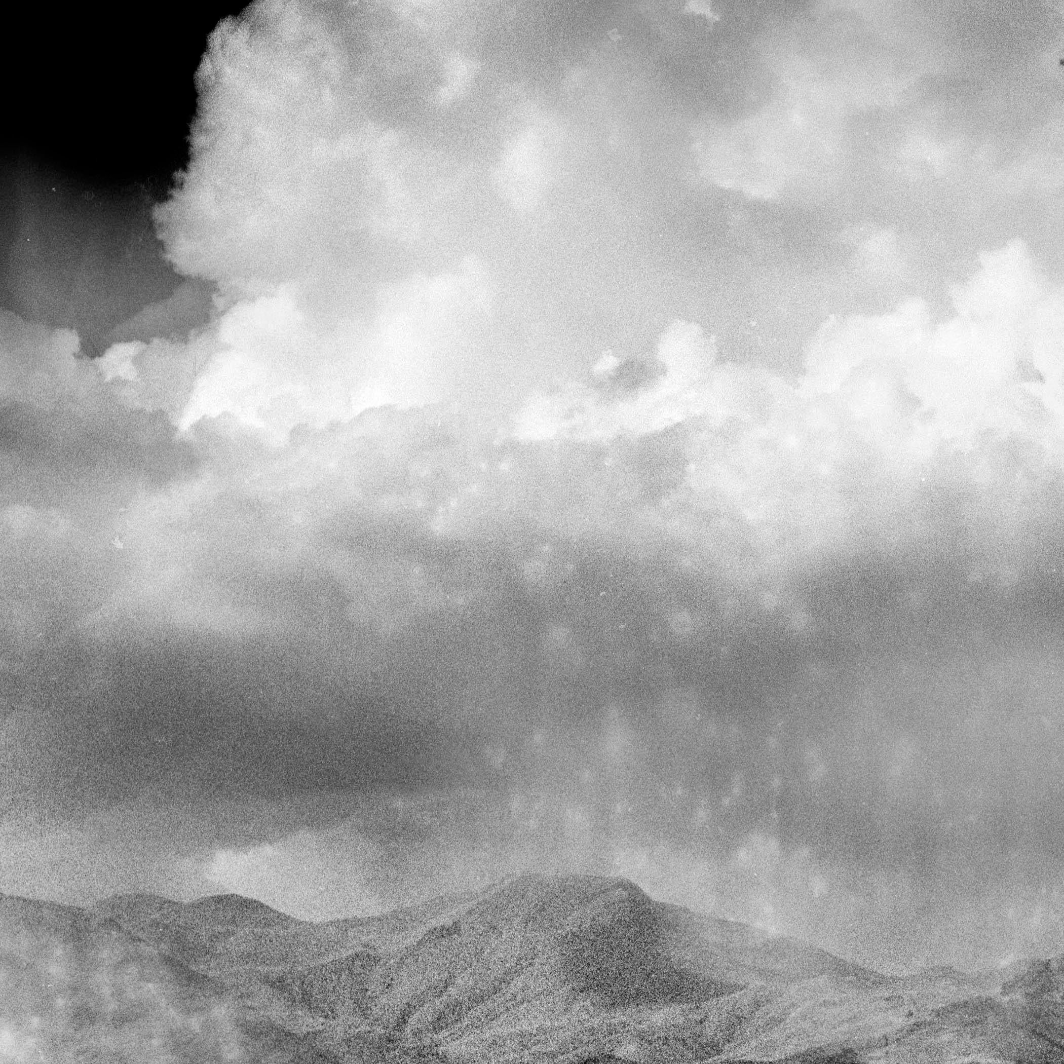 Une photographie de paysage en noir et blanc, magique et mystérieuse, prise dans les hautes terres d'Arménie. Au loin, là où se trouvent la brume et les montagnes, vous voyez des précipitations. Photographié avec un appareil moyen format Hasselblad