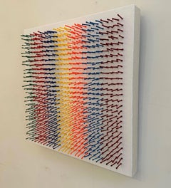 Abstract, sculptural, colorful artwork with strands of yarn piercing canvas