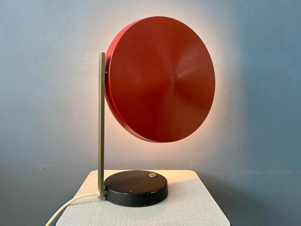 Lámpara de mesa vintage Egon Hillebrand 'Oslo' de Heinz Pfaender. La lámpara tiene un diseño único, con una pantalla roja oscura en forma de ovni que puede girarse en distintas direcciones. La lámpara necesita dos bombillas E14 y actualmente tiene