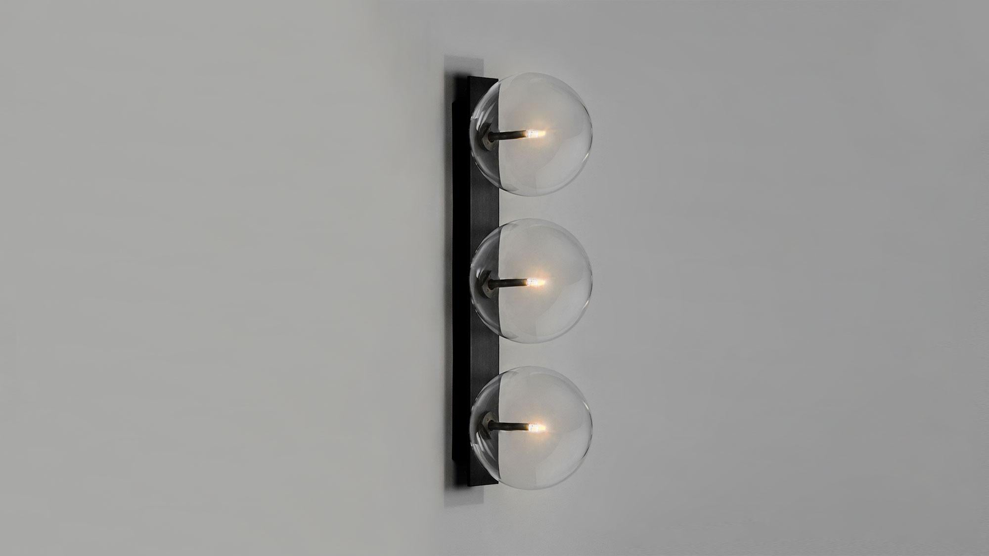Aplique triple Oslo
Tres burbujas de cristal se posan sobre un esbelto rectángulo de latón para un diseño esencial. Inspirados en las sobrias composiciones de la artista noruega de mediados del siglo XX Ragnhild Keyser, la singular curvatura de la