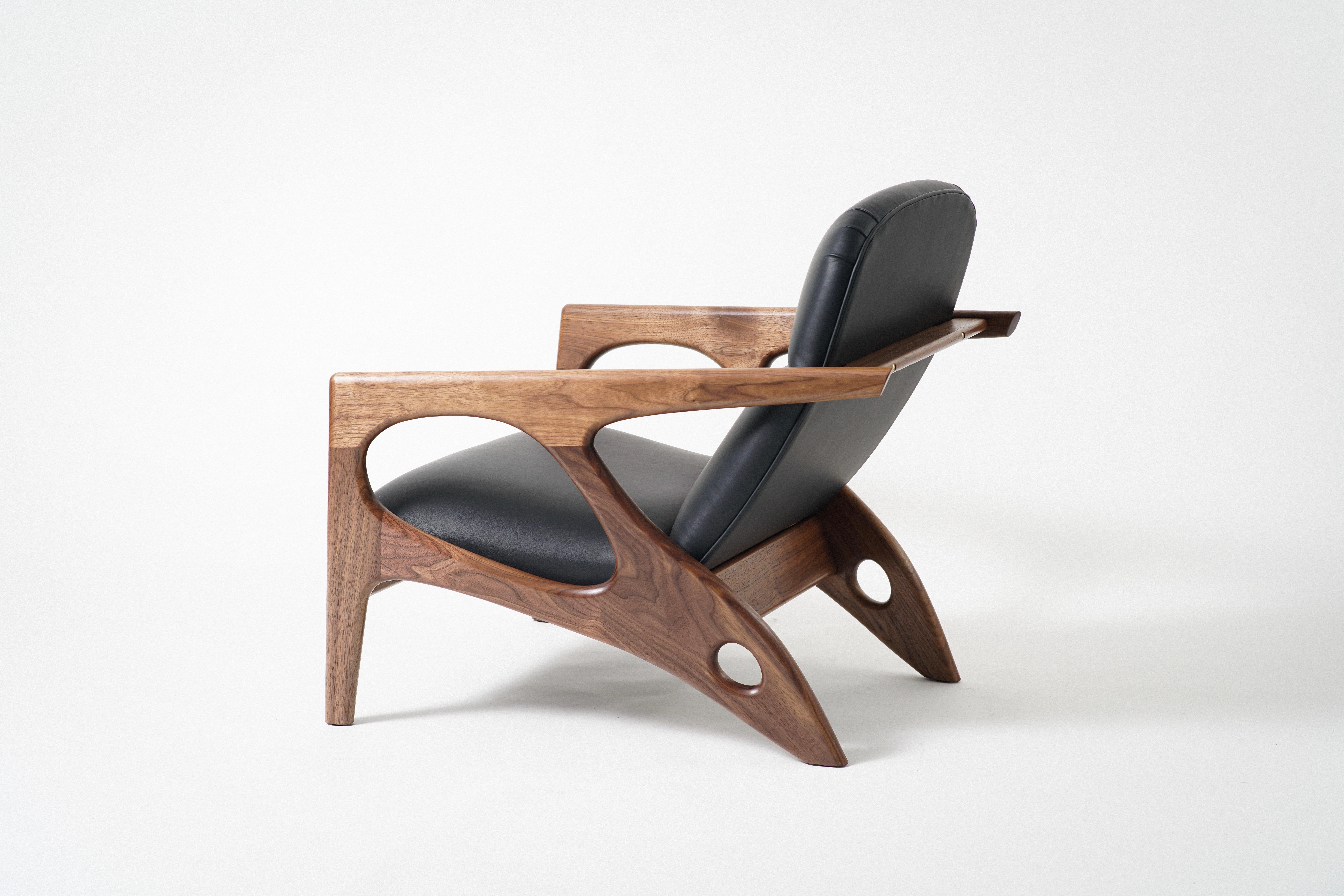 The Osprey Lounge Chair has an exposed hardwood frame that cradles an upholstered shell, with leather upholstery. The unique frame takes inspiration from both nautical design and the natural world. The generous frame opens up and tapers back, like a