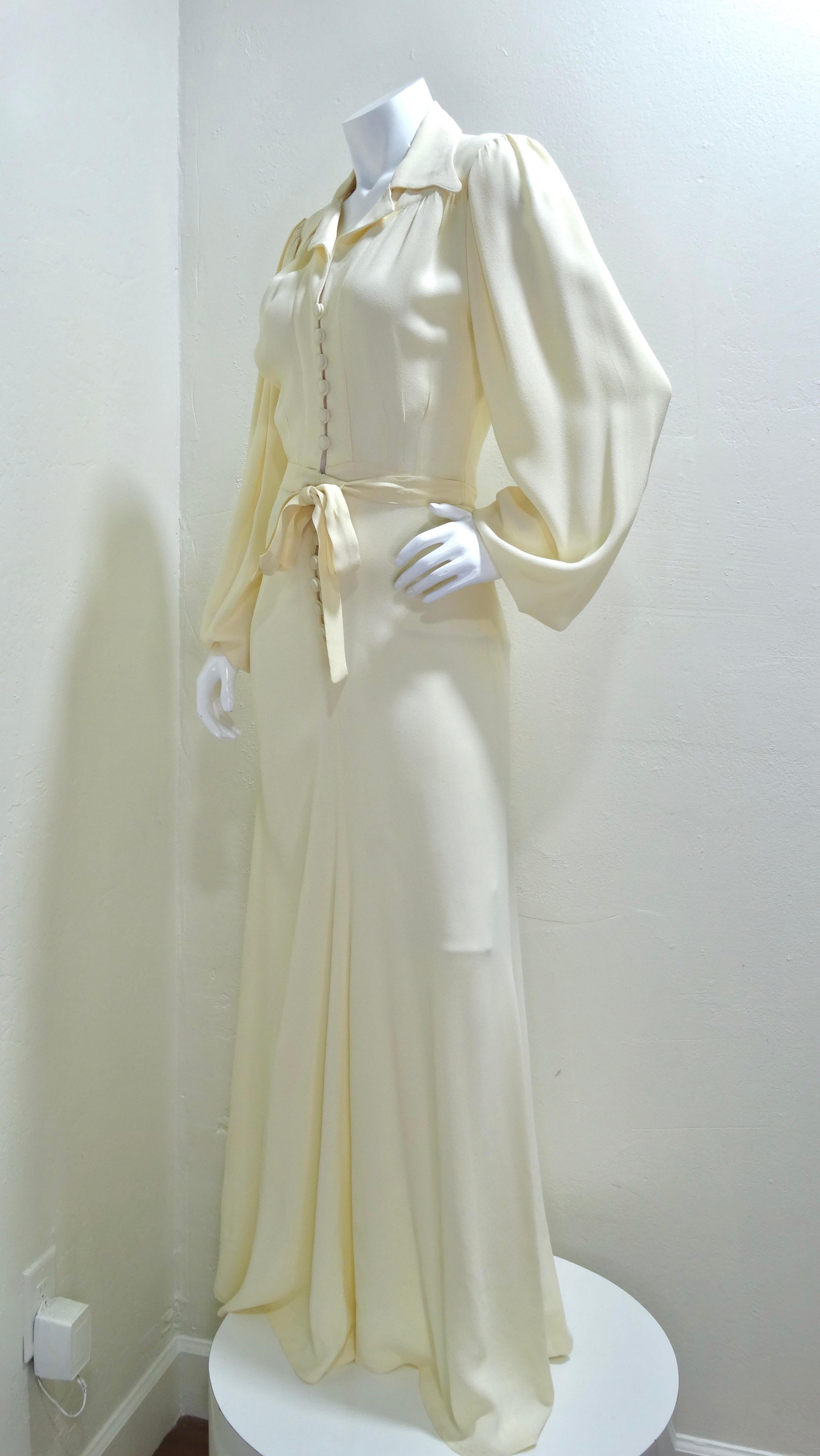 This Ossie Clark maxi-dress has a certain romance and timelessness about it. Made in the 1970's and composed of cream moss crepe in a maxi-length. The dress buttons up the front for a flattering and pinched waist and an exaggerated collar and