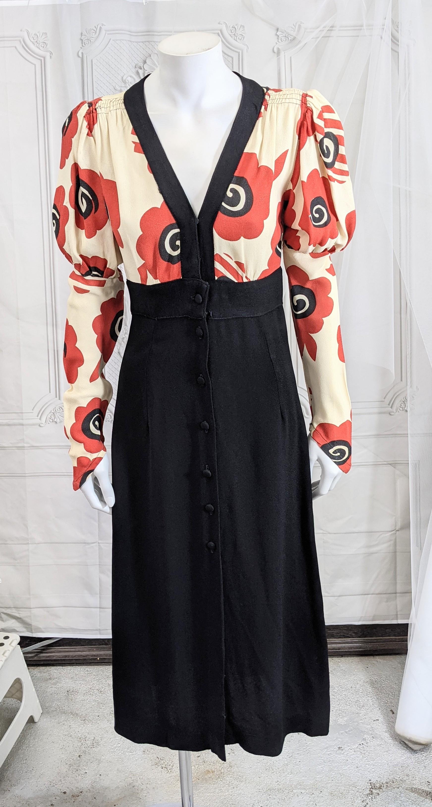 Iconic Ossie Clark for Radley black moss crepe day dress, with a red and black Art deco inspired poppy print by Celia Birtwell.  Self covered buttons, puffed sleeves narrow to wrist with a pointed edge. High waisted with flared A line skirt. 
Circa
