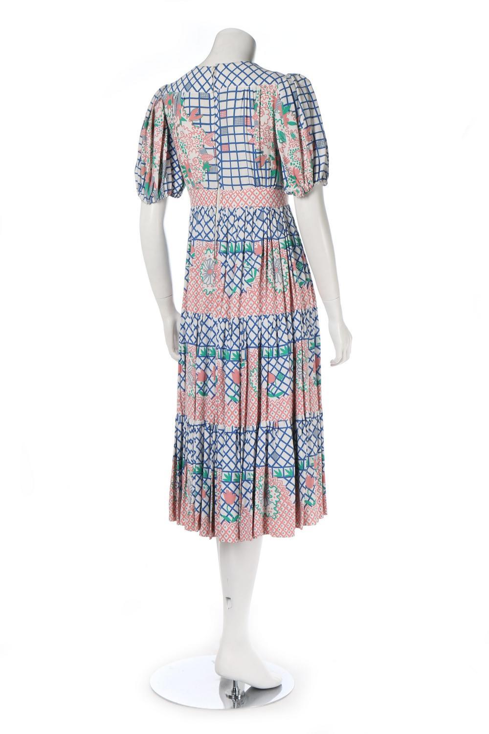 Ca. 1972 Ossie Clark/Celia Birtwell for Radley cotton short-sleeved dress with plunging v neckline, tiered skirt and abstract print featuring a blue windowpane check background sprouting pink flowers. In excellent condition. UK size 10  - please