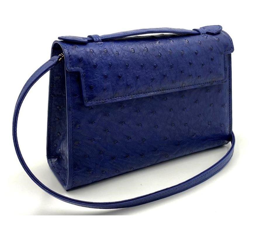 Real ostrich leather Blue color Single handle Hand painted profiles Internal pocket Removable shoulder strap Cm 215 x 145 x 65 (8.46 x 5.7 x 2.55 inches) Artisanally made in Italy
