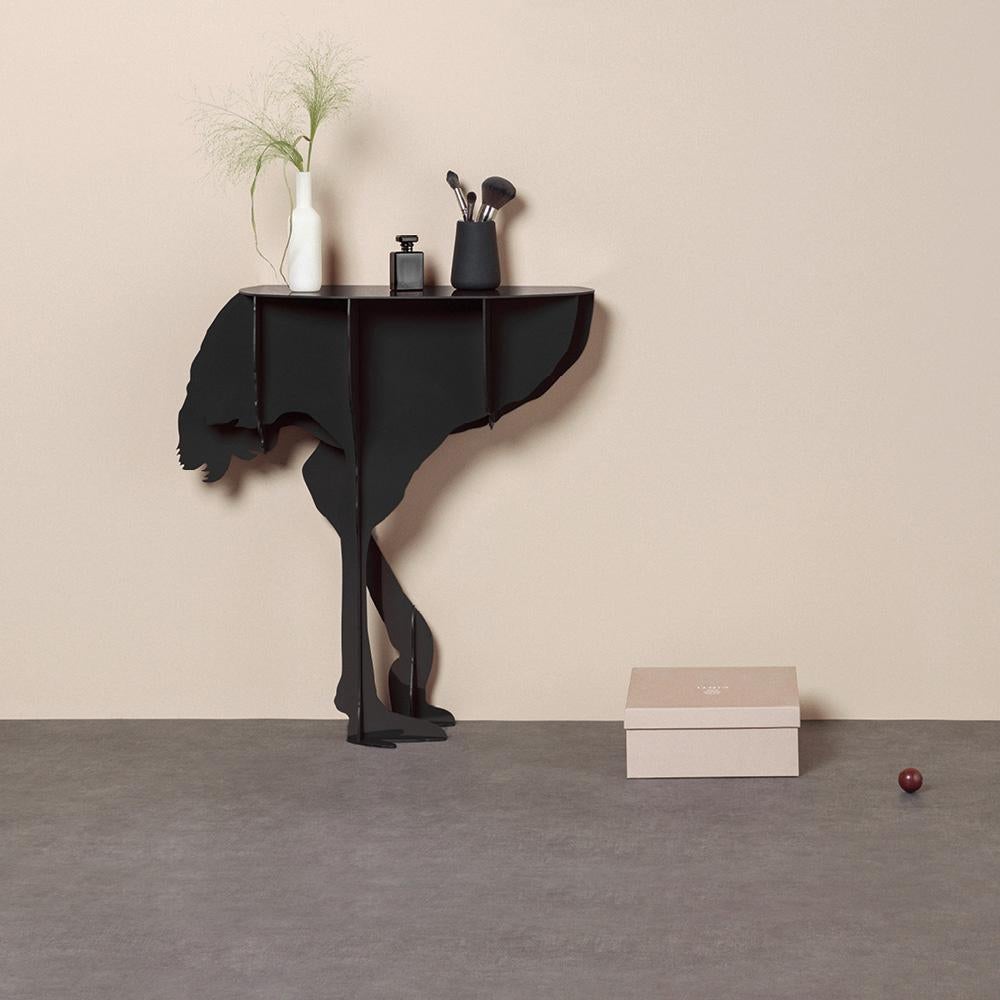 Diva, the aerial ostrich, seems ready to spread her wings in a daring dance, defying the laws of gravity with feet that only seem to skim the ground.

Intended to be fixed against a wall, the elegant and practical console surprises with its feminine
