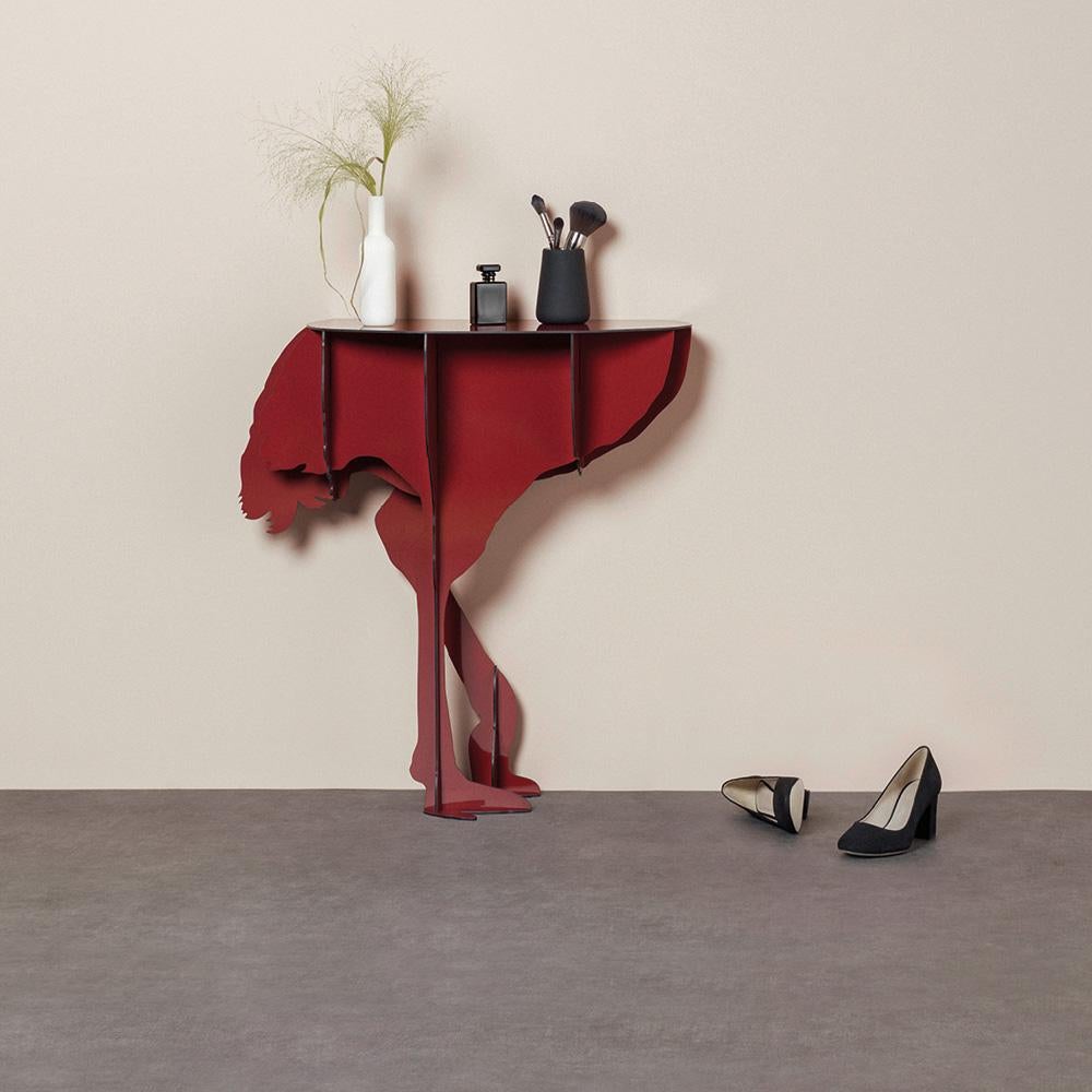 Diva, the aerial ostrich, seems ready to spread her wings in a daring dance, defying the laws of gravity with feet that only seem to skim the ground.

Intended to be fixed against a wall, the elegant and practical console surprises with its feminine