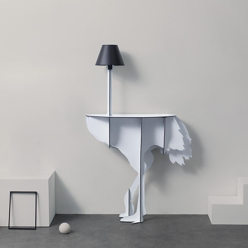 Diva Lucia, the aerial ostrich, seems ready to spread her wings in a daring dance, defying the laws of gravity with feet that only seem to skim the ground.

Intended to be fixed against a wall, the elegant and practical console surprises with its