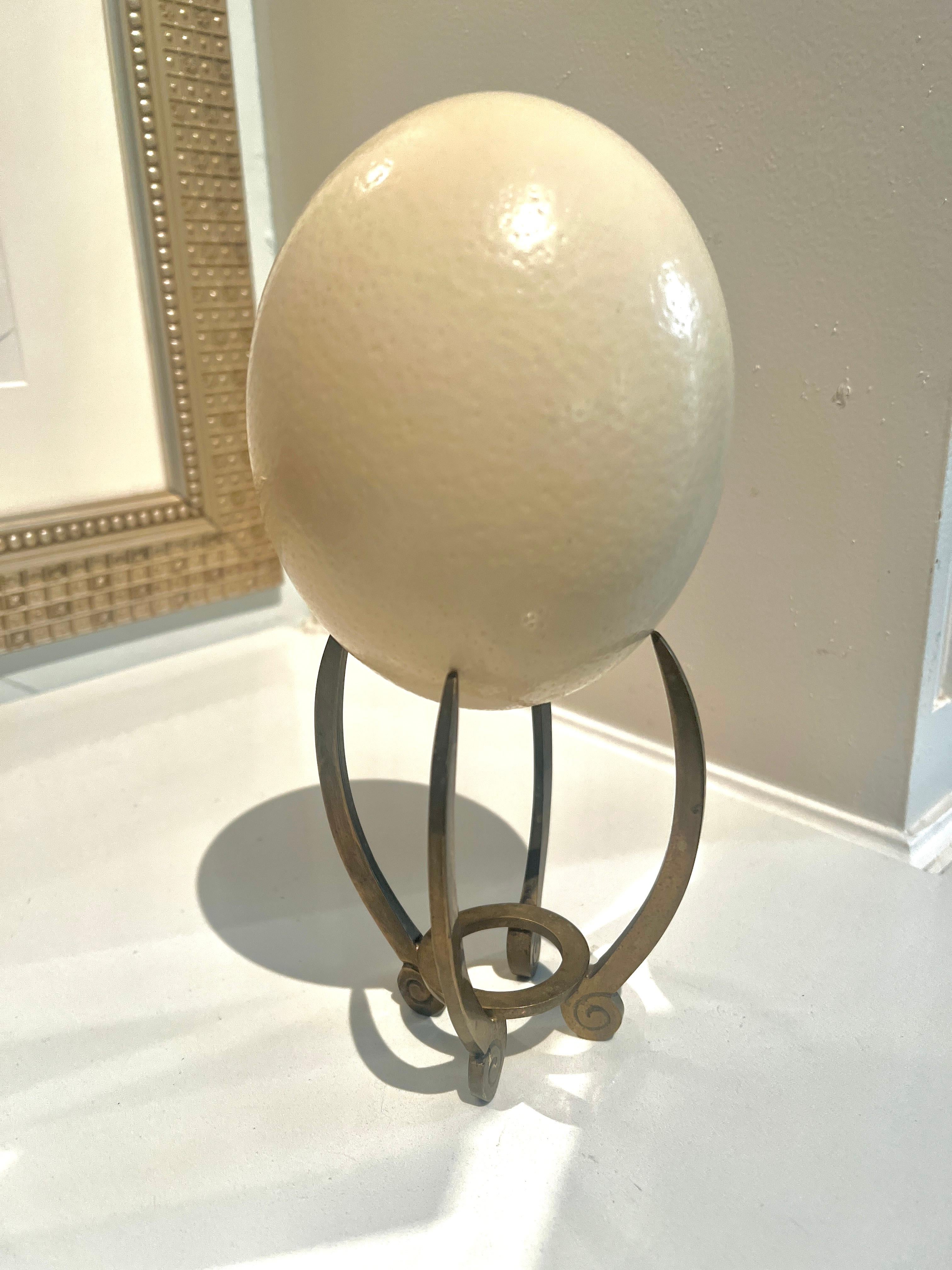 A beautiful Custom Brass Stand with Scroll design and an Ostrich Egg.  

The Ostrich Egg is interchangeable with a crystal or Murano Paperweight.  This gives a collection of objects height and interest.

A compliment to any side table, console table