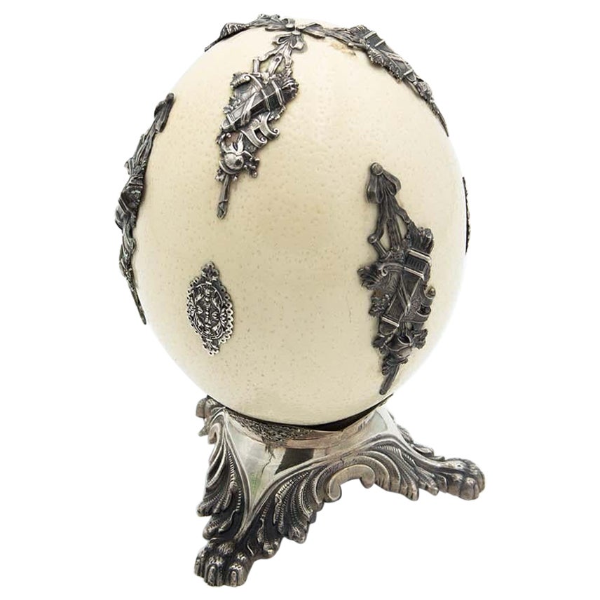 Ostrich egg resting on three silver support feet