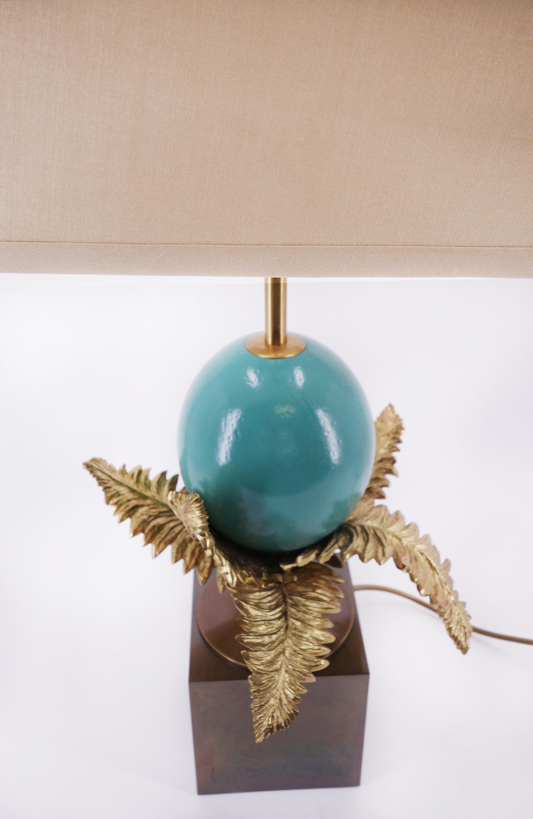 This beautiful table lamp s a unique piece which includes a turquoise colored ostrich egg and detailed brass leaves on a bronzed base.

 