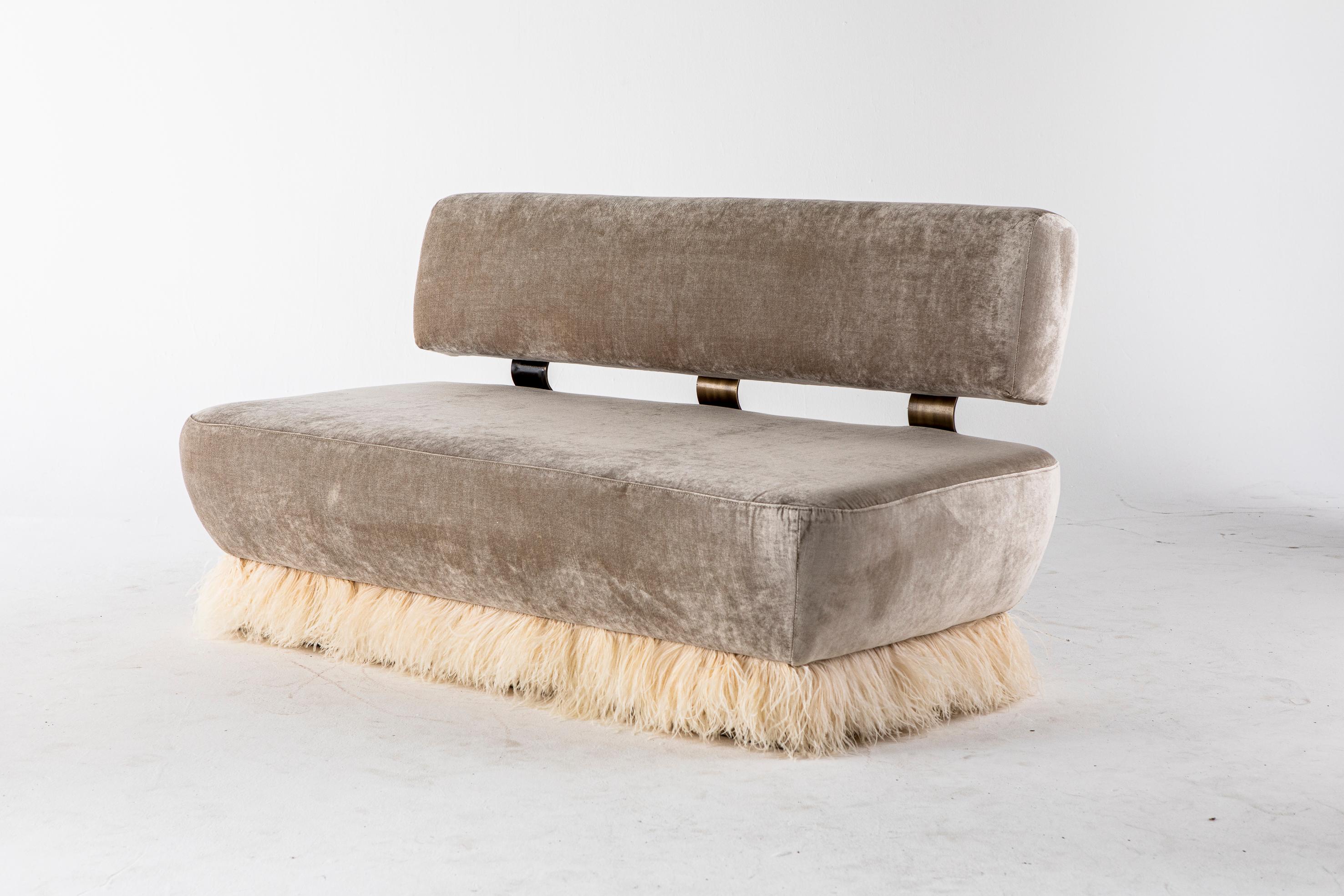 Ostrich fluff sofa by Egg Designs.
Dimensions: 160 L X 79 D X 85 H
Materials: antique brass coated steel, brass buttons, ostrich feather trim, velvet upholstery.

Founded by South Africans and life partners, Greg and Roche Dry - Egg is a unique