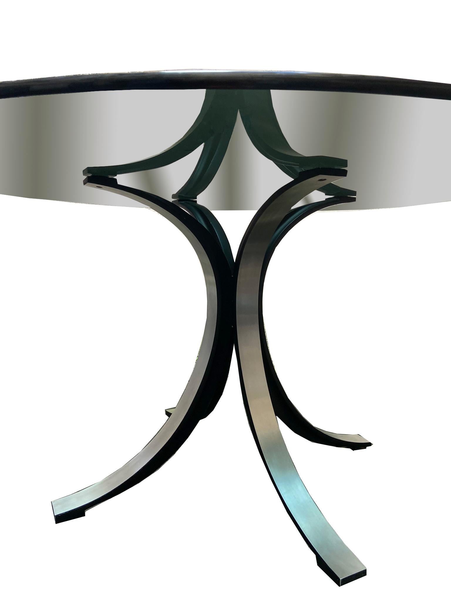 T69 round dining table, designed by Osvaldo Borsani and Eugenio Gerli in the 1960s and produced by TECNO. Characteristic feature of the table is the supporting structure built by the crossed joint of two equal metal elements with enameled internal