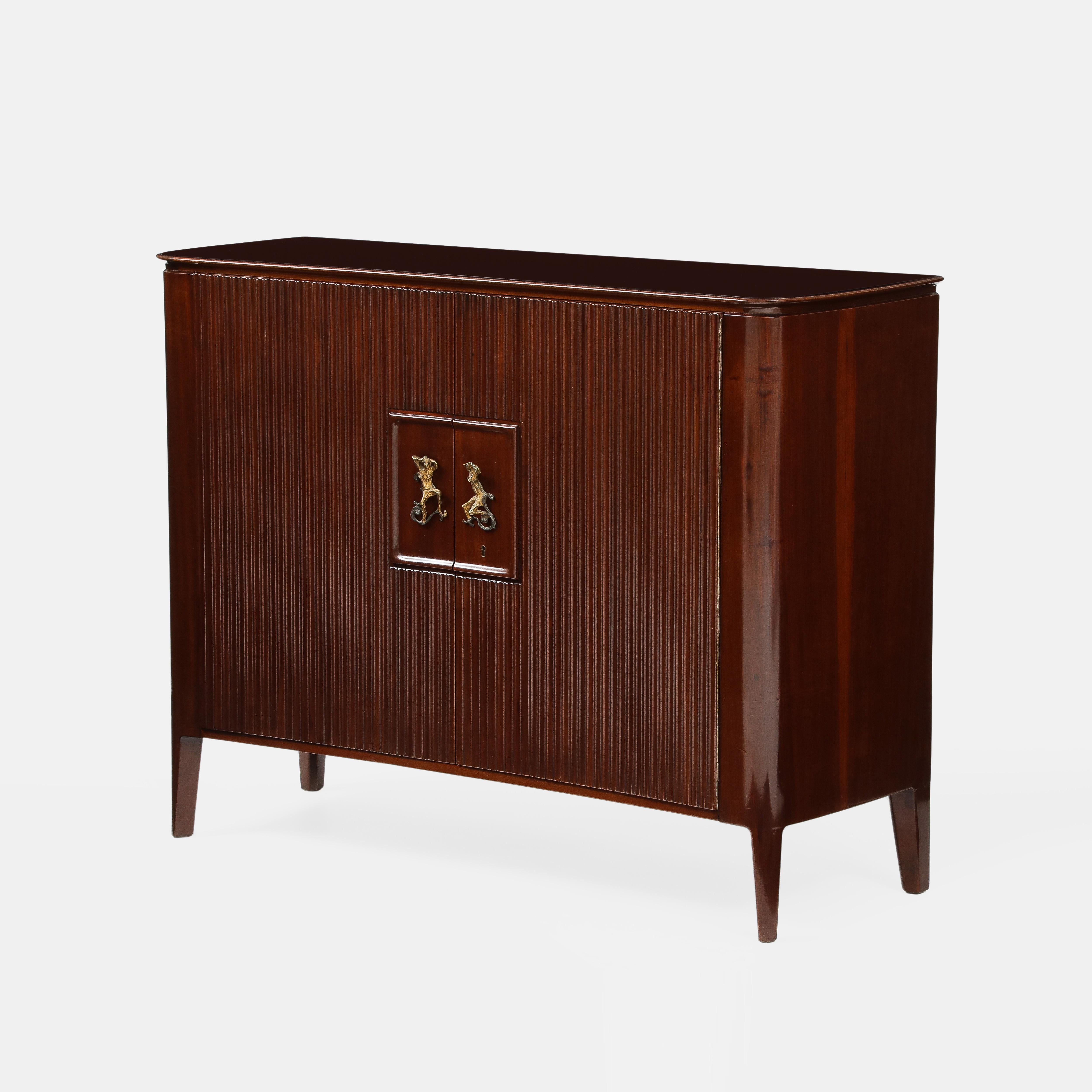 Osvaldo Borsani pour AVB (Arredamenti Borsani, Varedo) rare et extraordinaire armoire ou buffet à deux portes à façade cannelée en acajou décoré de poignées de porte en bronze moulé par Lucio Fontana, Italie, années 1950.  Le dessus du meuble est