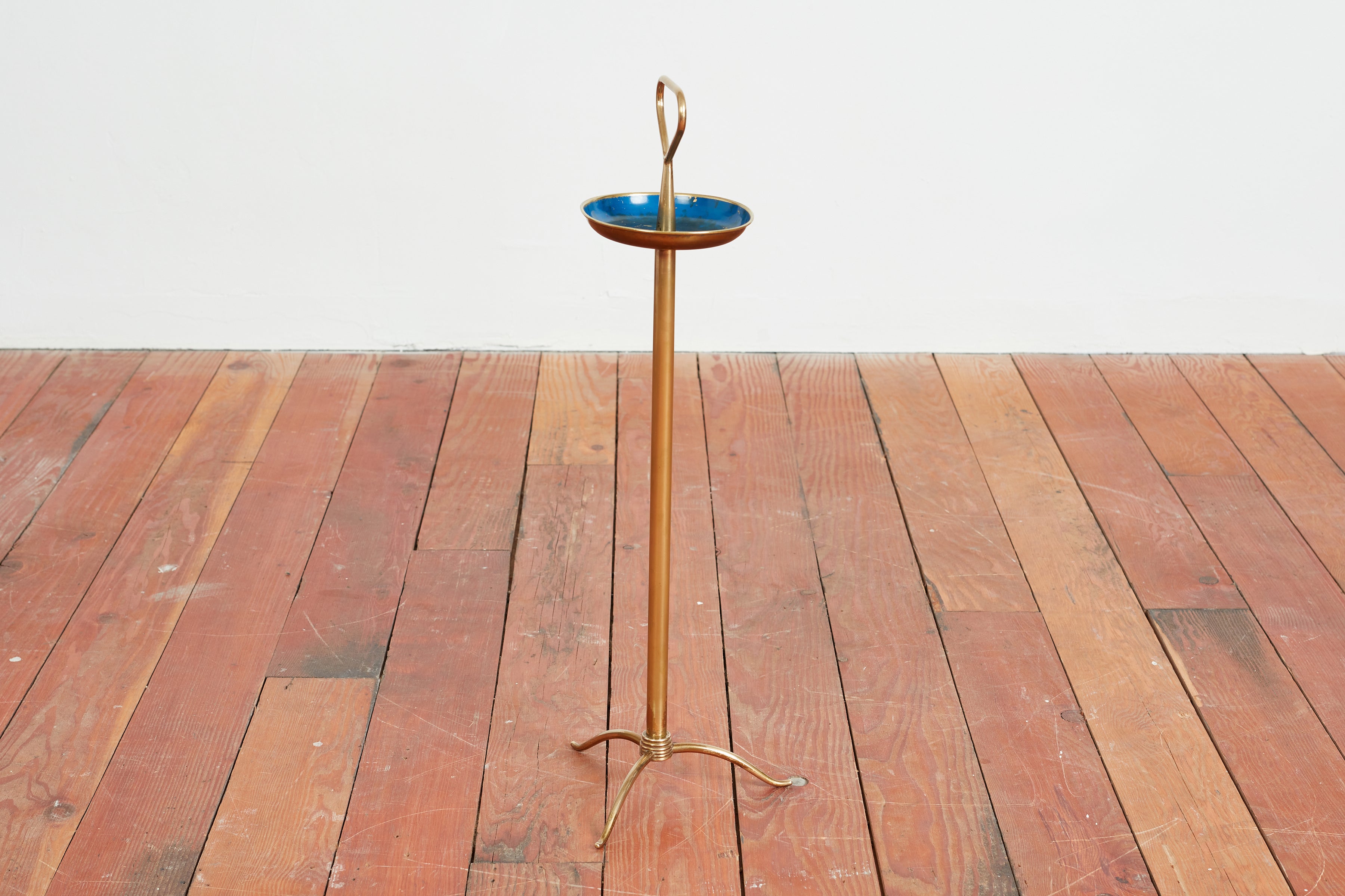 Elegante posacenere attribuito a Osvaldo Borsani - Italia, anni '50
Base a treppiede in ottone con piatto smaltato di blu con una splendida patina. 
Maniglia triangolare in ottone per poter spostare il pezzo. 


