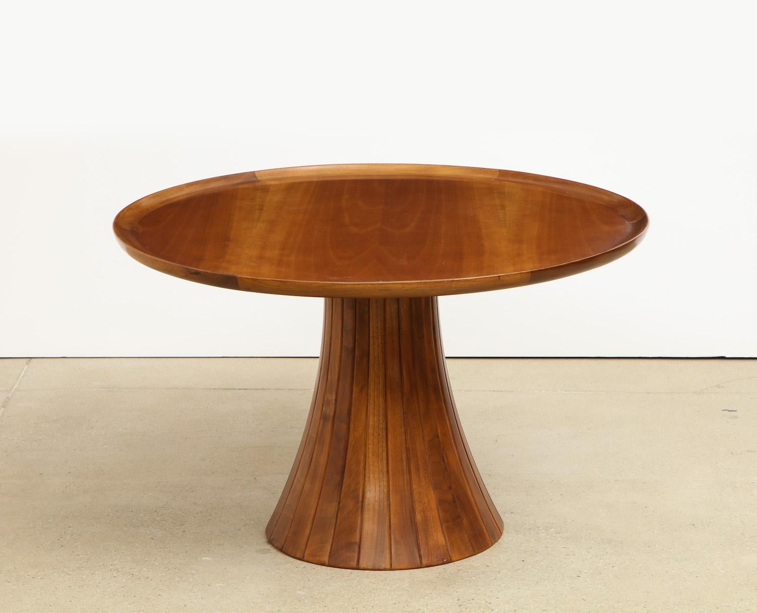 Walnut table featuring a wide pedestal base with incised vertical lines. Circular top with beautifully figured wood and elegant outside lip. This table was custom made for a home in Milano that featured many Borsani pieces and is believed to have