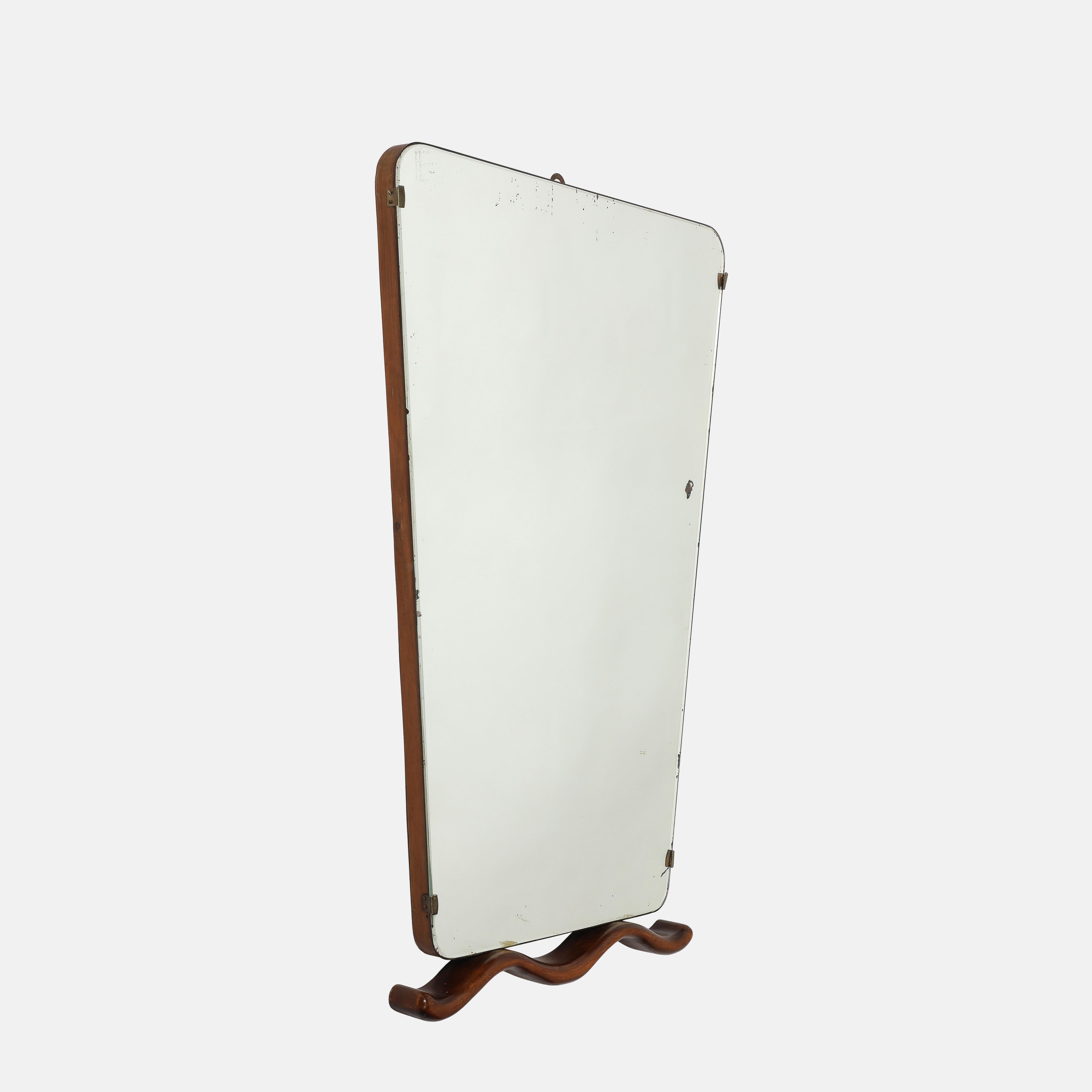Raro espejo rectangular con marco de madera y cristal de espejo original que se estrecha hacia la parte inferior, con monturas de latón y detalle decorativo de madera ondulada tallada en la parte inferior del espejo, atribuido a Osvaldo Borsani,
