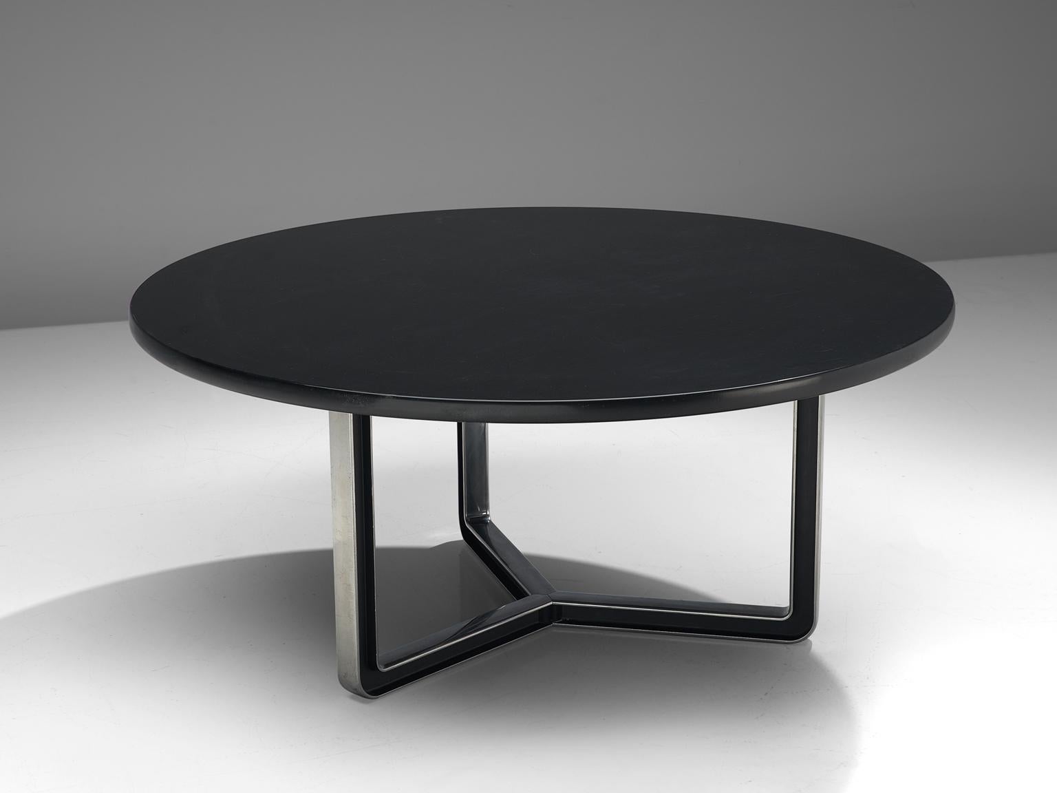 Osvaldo Borsani for Tecno, conference table T334-C, aluminum and wood, Italy, 1975-1978.

Round conference table with a black top. The base consists of a three-legged metal frame. The base creates an open character with the dark top and aluminum