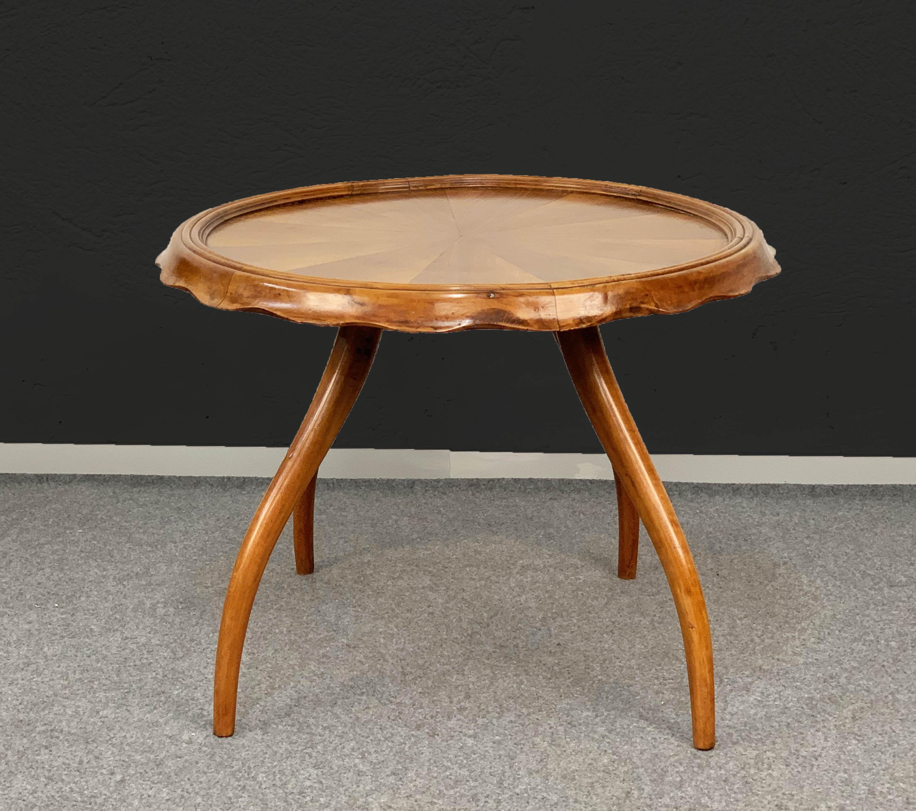 Refined and elegant round table by Arredamenti Borsani, 1930s four sinuous curved legs, an important edge in the shape of a bottle stopper. Excellent condition, beautiful original patina blonde walnut 
Measurements: Height 49 cm; diameter 65 cm.