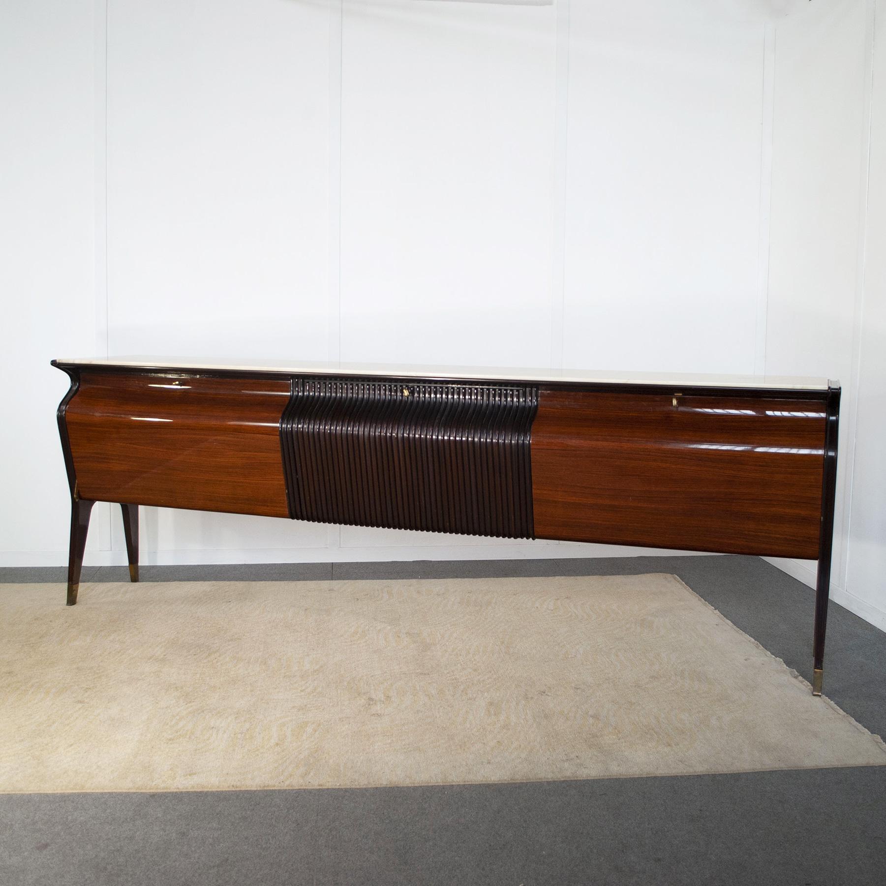 Buffet sideboard in beech veneer and ebonized grising, brass ferrules, marble top production Atelier di Varedo designer Osvaldo Borsani 1950s.


Osvaldo Borsani was born in Varedo in Brianza in 1911 into a family of furniture manufacturers with a