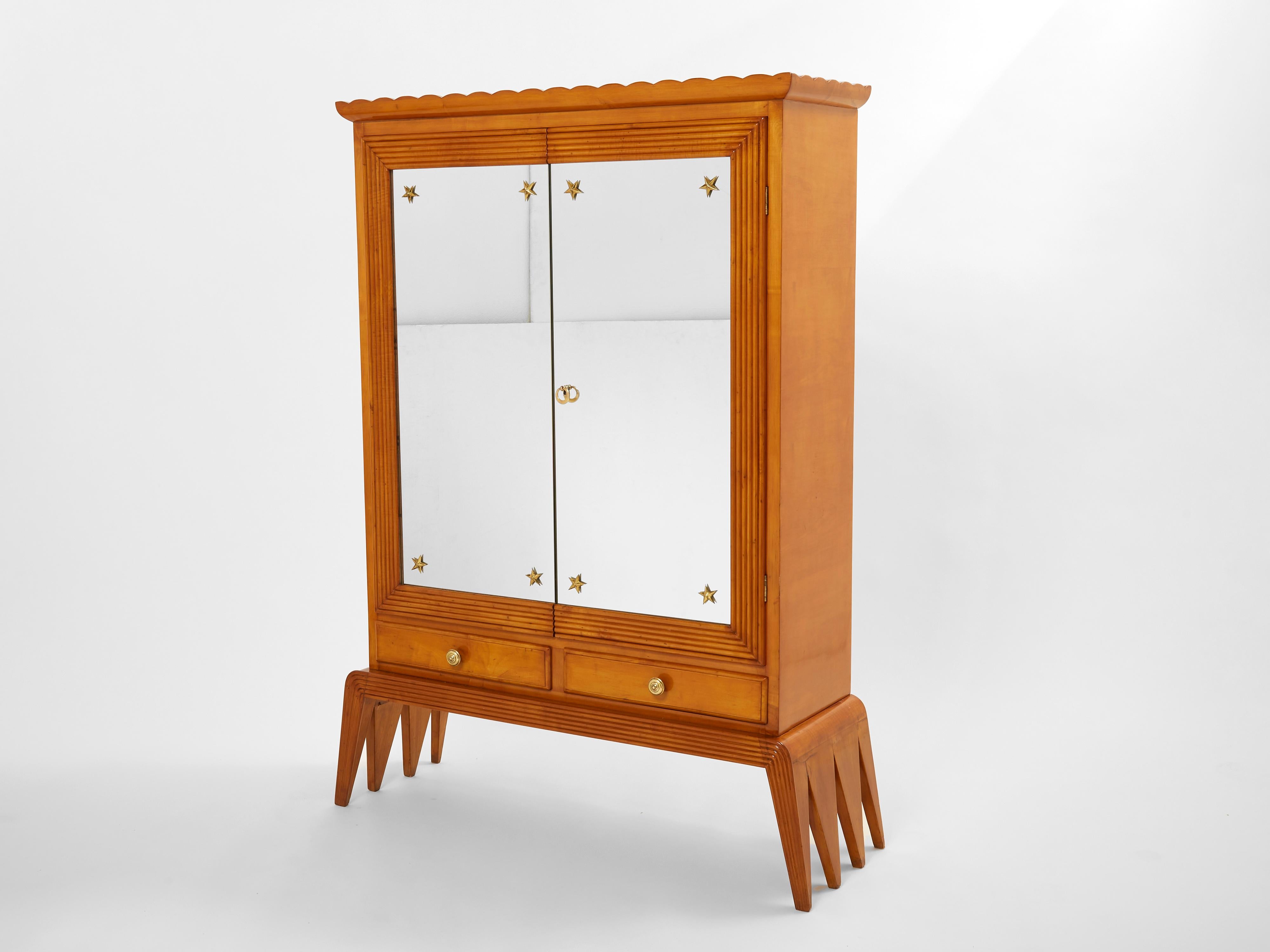 A rare Osvaldo Borsani bar cabinet (mobile bar) produced by Arredamenti Borsani Varedo in Milano in the mid-1940s. It features a body in cherry wood with incised relief lines framing two mirrored doors with brass stars in the corners of each, two