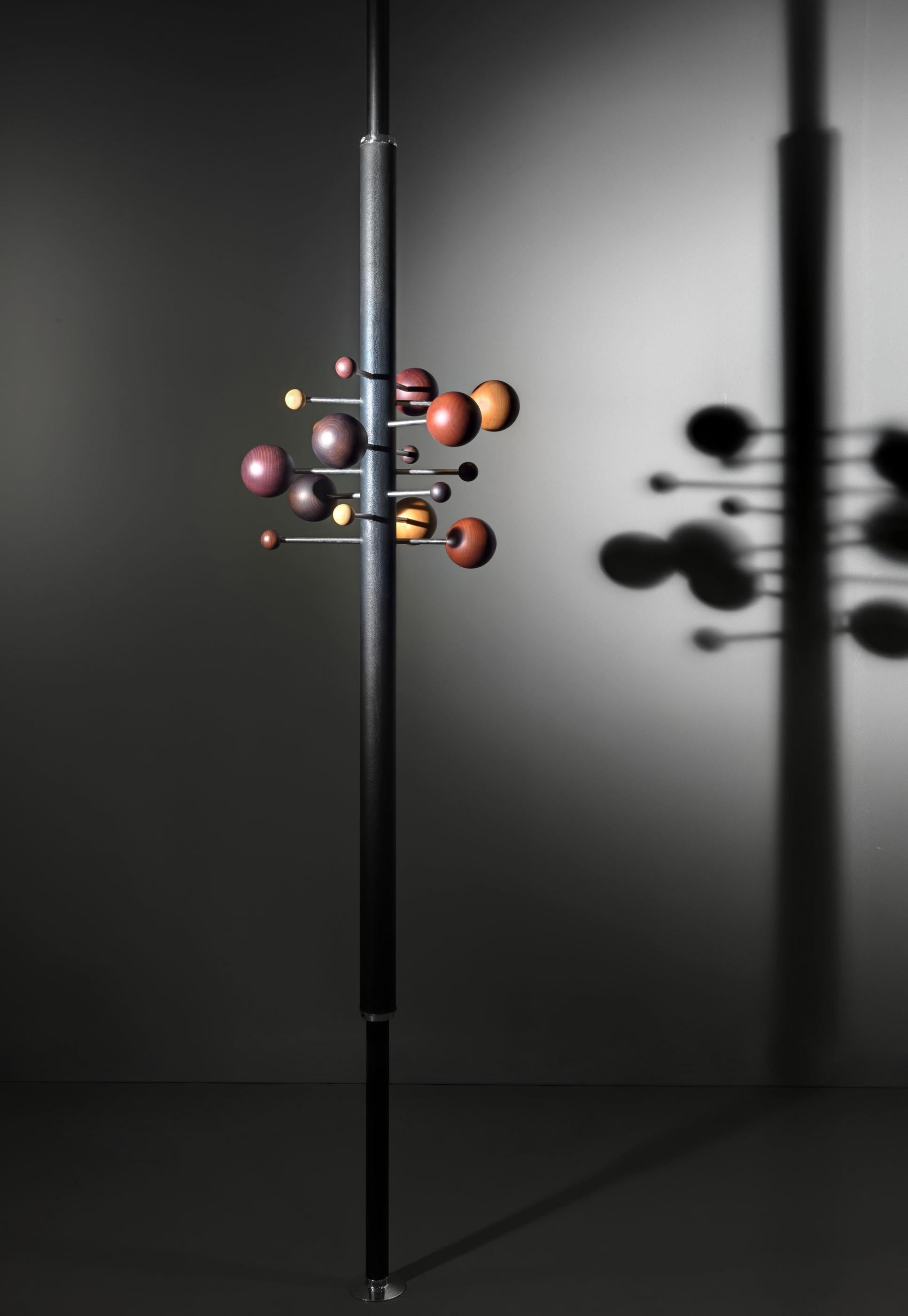 Coat rack model AT16, designed in 1961 by Italian designer Osvaldo Borsani, is a compressed rotating coat hanger composed of two interlocking leather covered aluminum tubes with brushed stainless steel rods with coat hanger balls on either end. Rods
