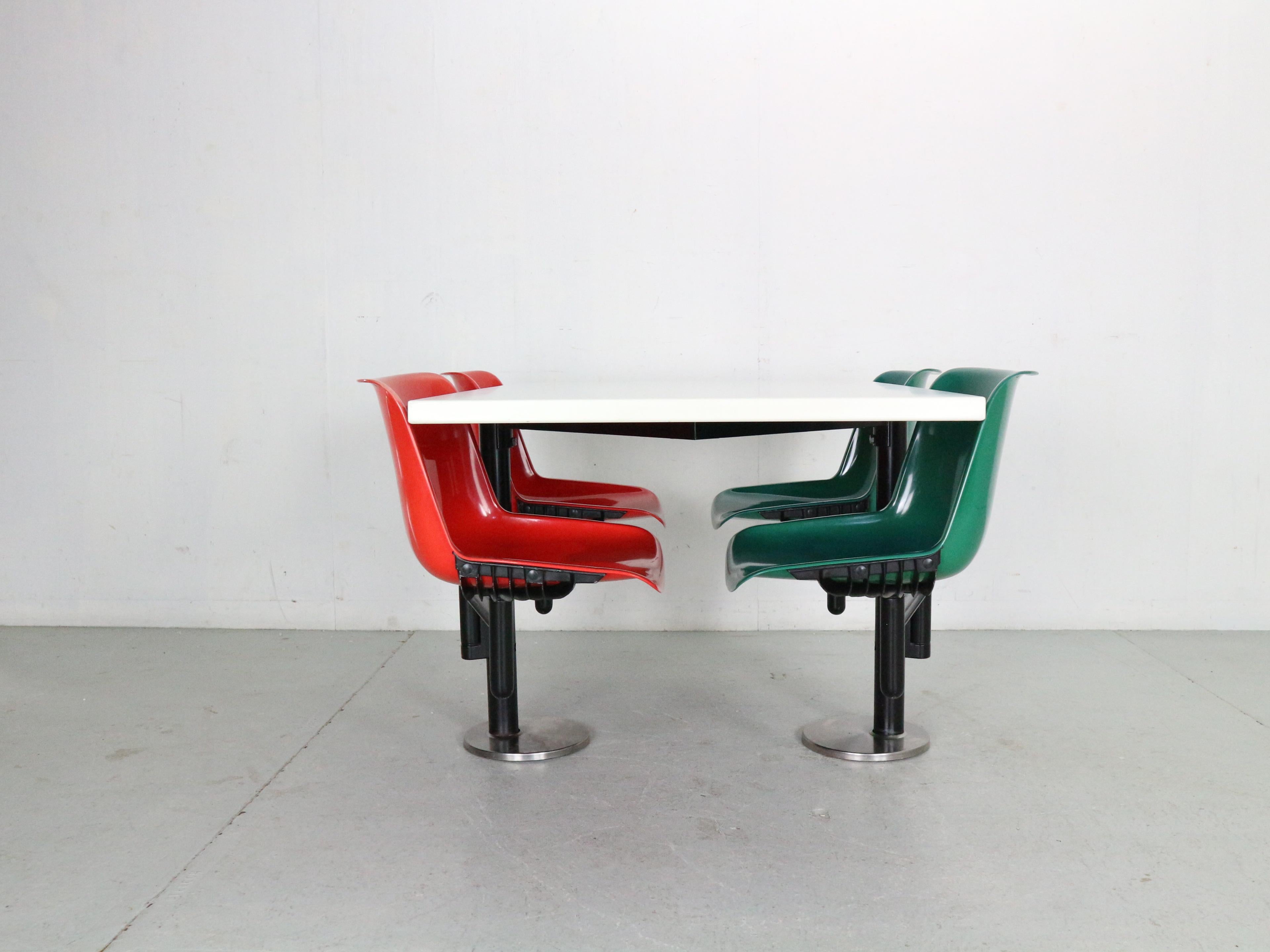 This contemporary design iconic dining room set designed by Osvaldo Borsani and manufactured for Tecno in 1970s period, Italy.

White table and four integrated swivel chairs in red& green plastic on cast steel structure- easy assembly and