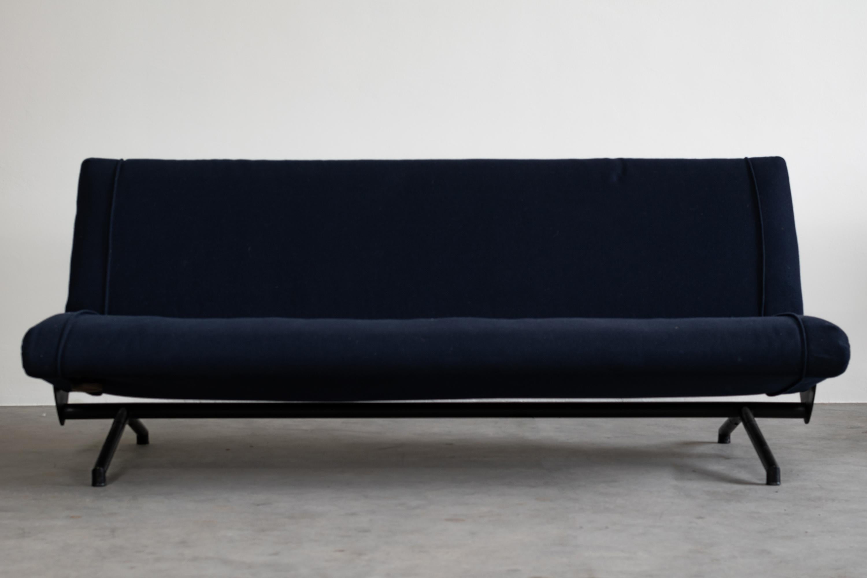 The customizable D70 sofa has two pivoting wings, a metal frame, polyurethane foam filling, and blue fabric upholstery, designed by Osvaldo Borsani in 1953 and manufactured by Tecno.

The opening mechanism consists of a lever with a securing pin