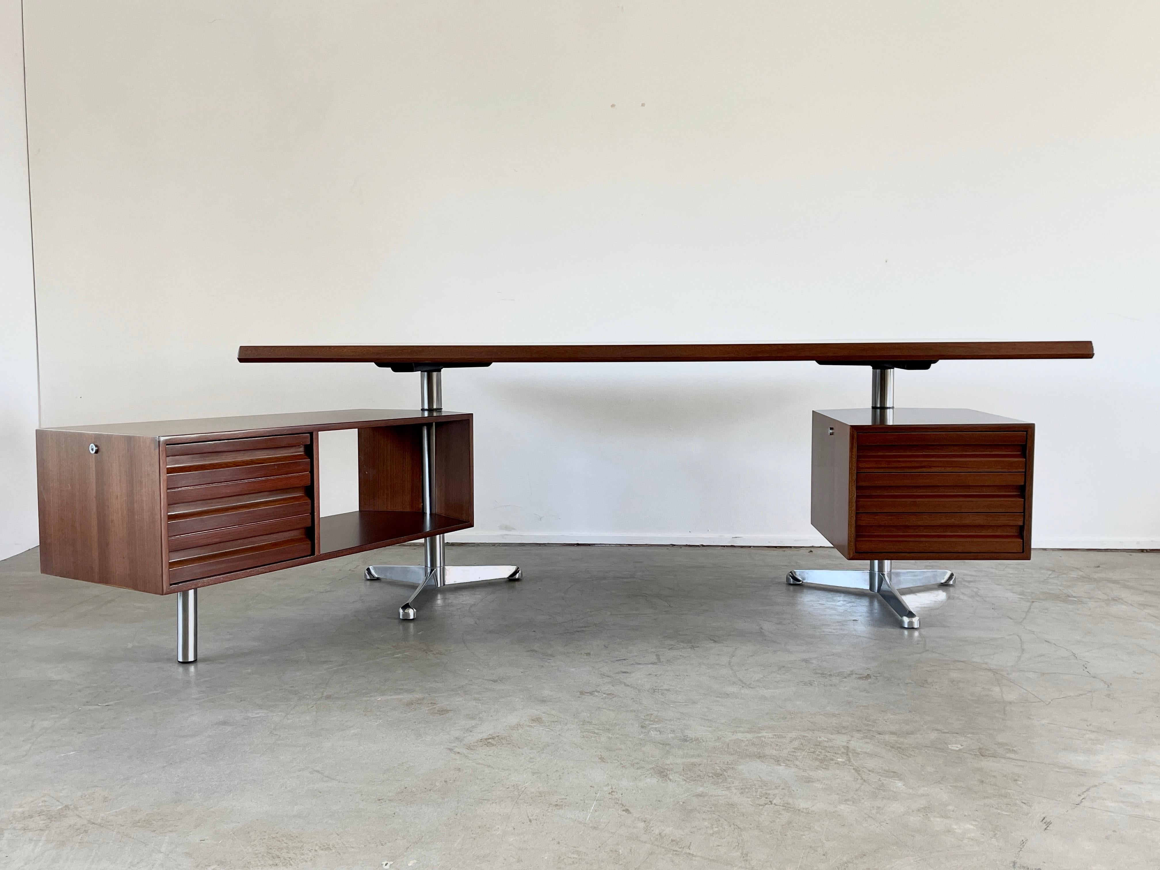 Fantastic rosewood desk by Osvaldo Borsani beautifully refinished in French polish. Floating desk top sits on tripod nickel bases with articulating left side storage cabinet which features three drawers. Additional three drawer cabinet floats on