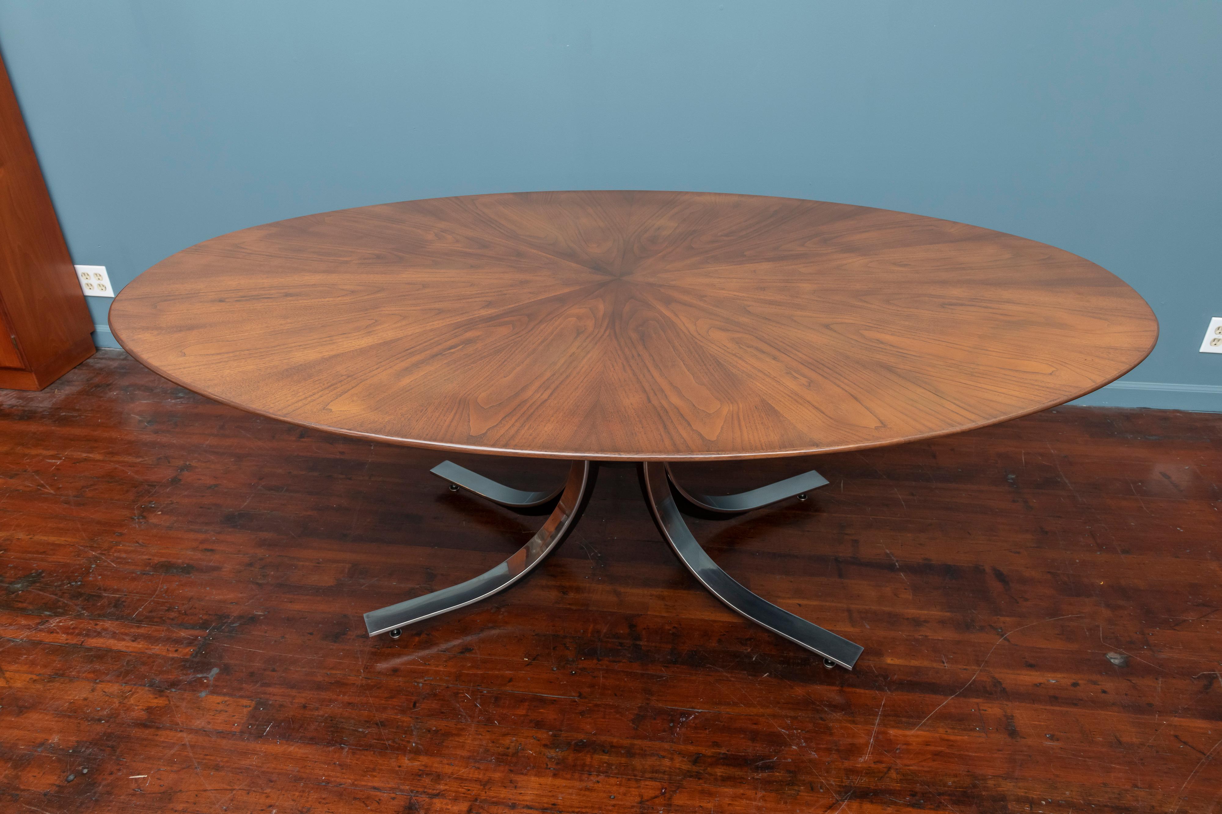 Osvaldo Borsani design sunburst walnut veneer top dining table on a sculptural chrome and steel splayed leg base. Newly refinished top with age appropriate scuffs and wear to the chrome sleeved legs.