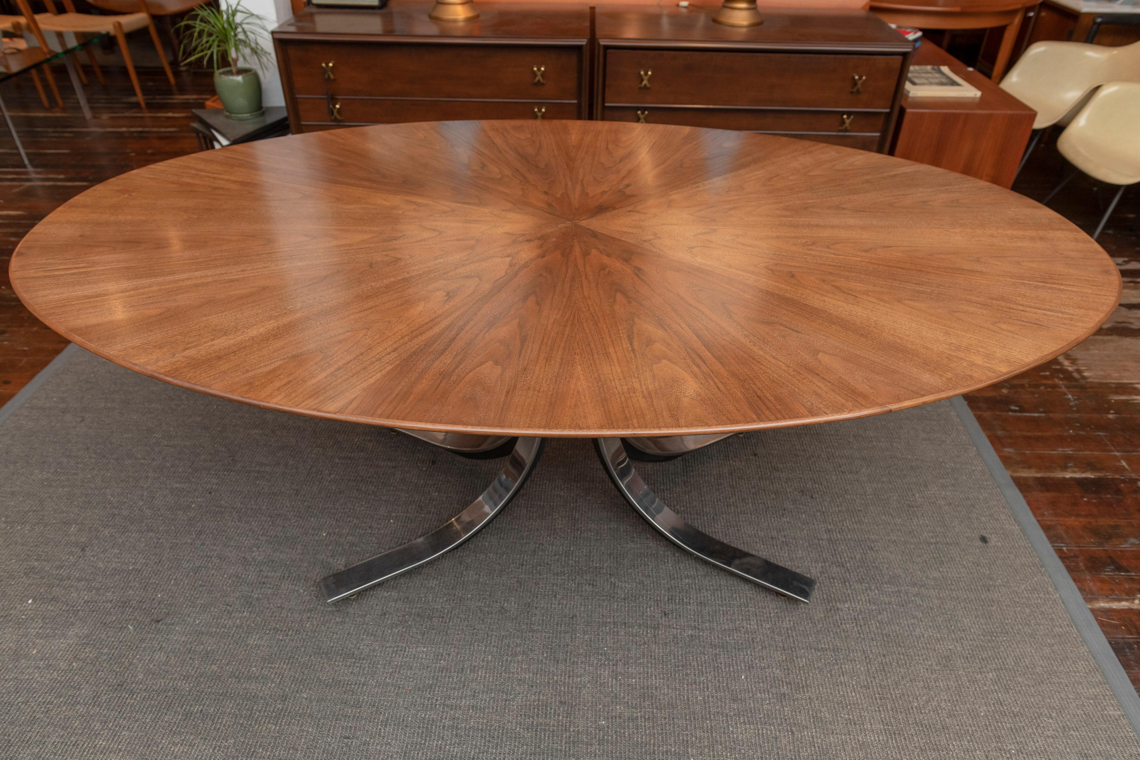 Osvaldo Borsani design walnut oval dining table for Stow Davis. Gorgeous starburst pattern veneered top just newly refinished with a custom made under frame to raise the table to standard dining height. 
Steel and chrome splayed leg base with