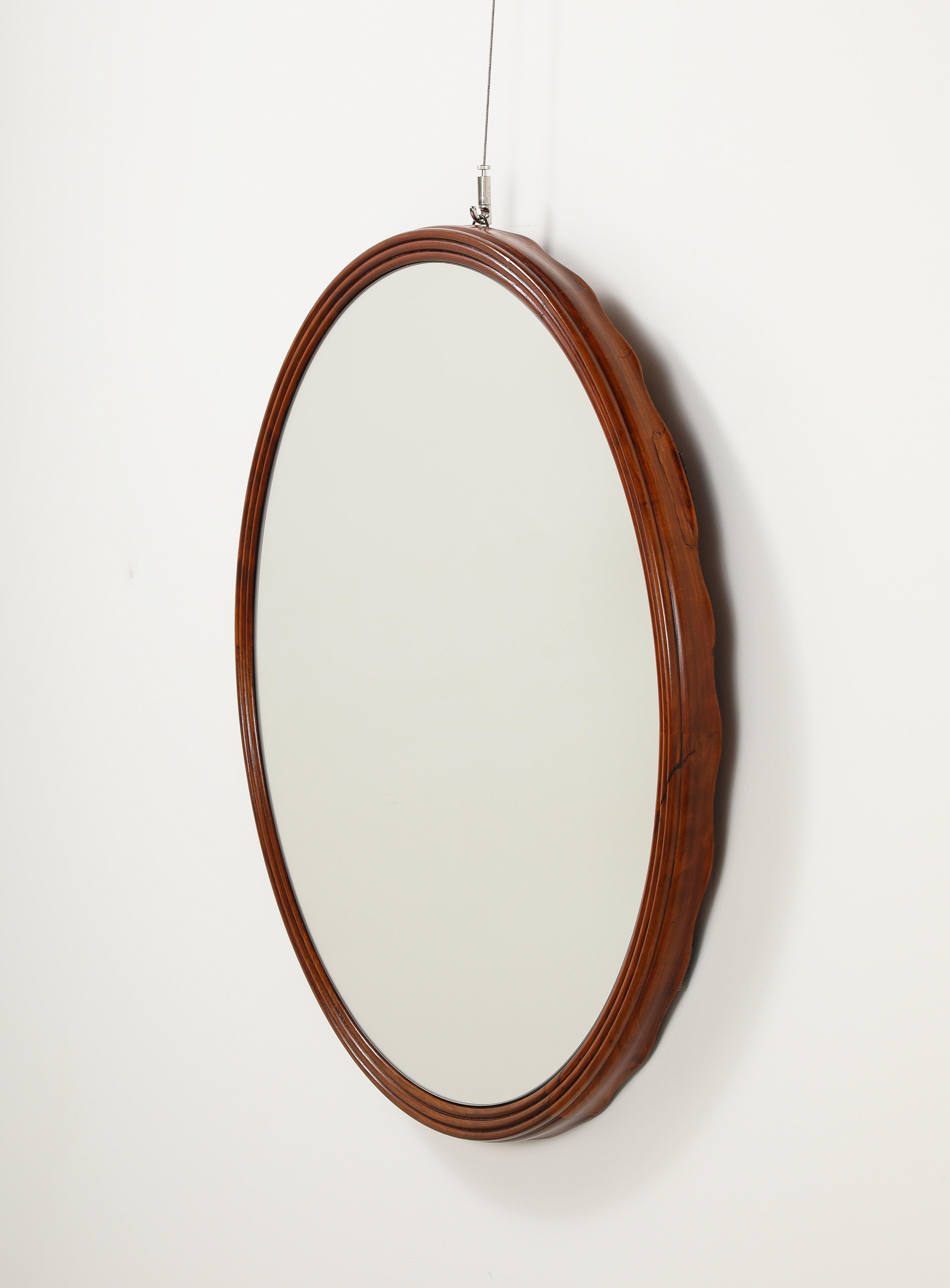 An Osvaldo Borsani Varedo finely carved walnut wall-mounted console table with mirrored surface and accompanying circular walnut wall mirror with elegant scalloped edge.  The rectangular mirrored surface is supported on a hand-carved walnut frieze