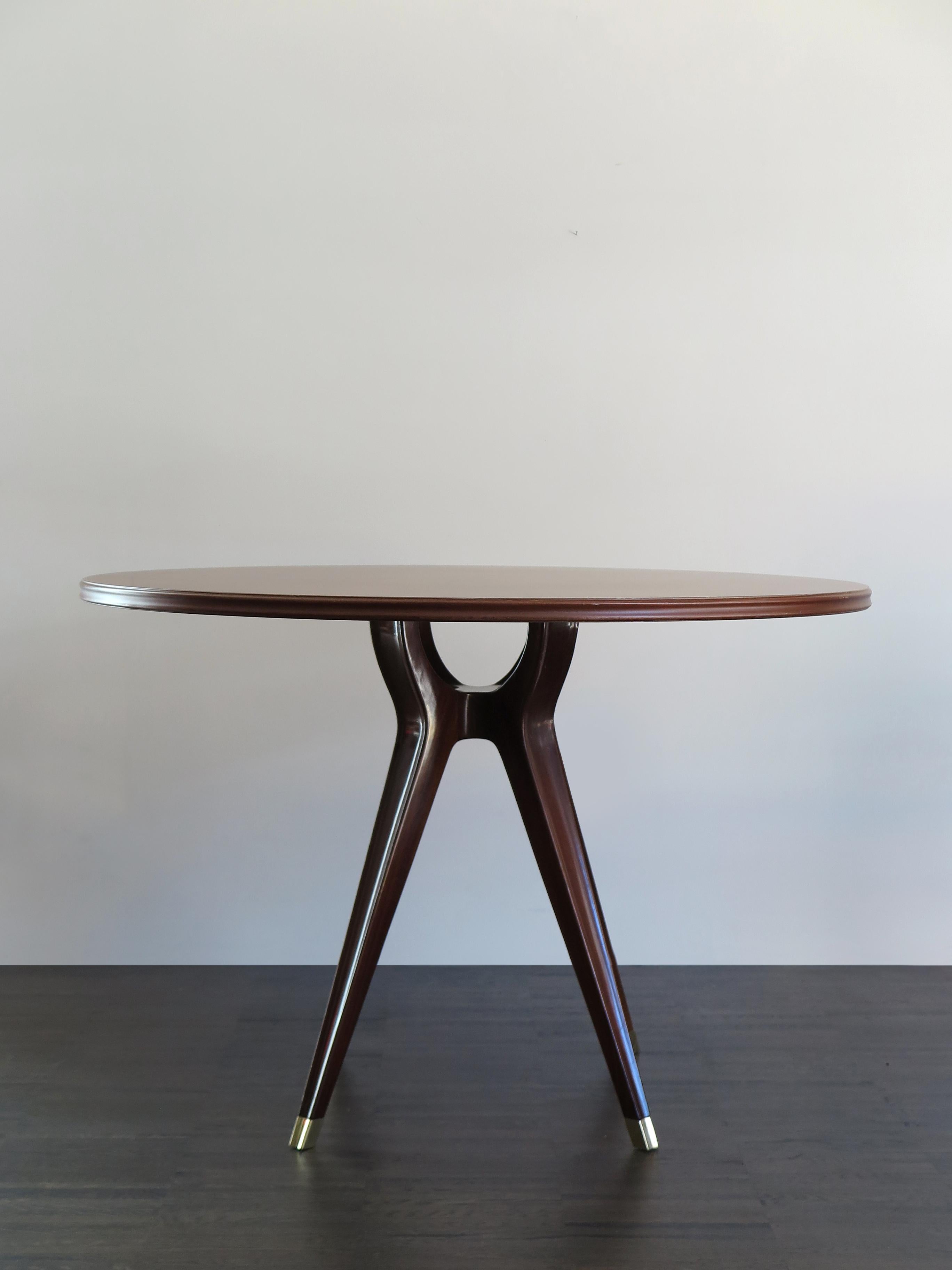 Italian Mid-Century Modern design round dining table designed by Osvaldo Borsani and produced by Arredamenti Borsani, dark wood foot structure with brass finials and dark wood veneer top, circa 1951.

Accompanied by a certificate of authenticity