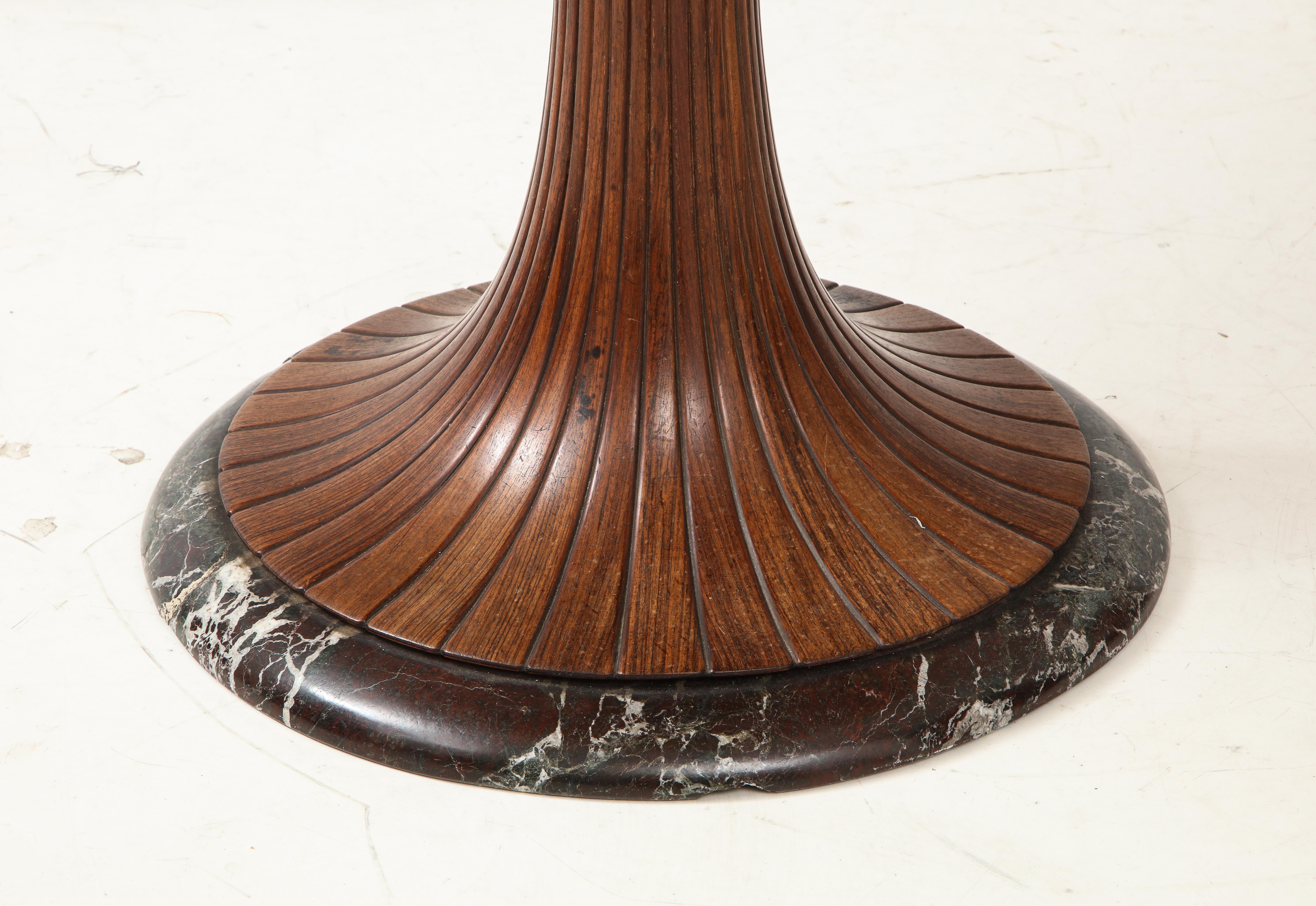 An Osvaldo Borsani tulip shaped dining table or center table. Designed for Arredamento Borsani, Italy, 1950s. The tulip shaped walnut base is elegantly carved and fluted, with a marble surround at the base; the top a beautifully contrasted