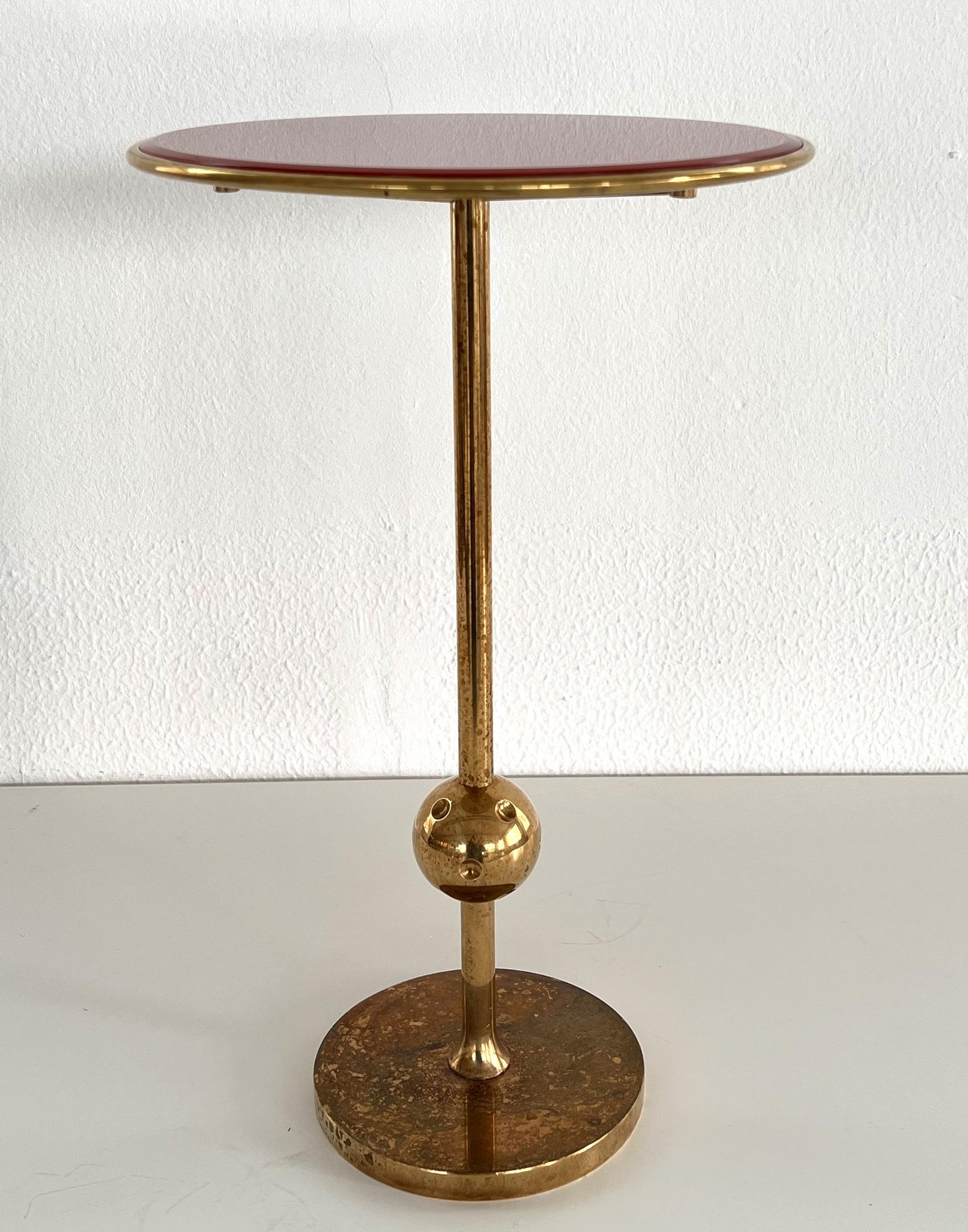 Beautiful iconic side table made in full brass and painted glass top in red color.
Designed in the 1940s by Osvaldo Borsani and produced in Tecno company in Northern Italy, Varedo.
These brass tables have never been produced in mass production but