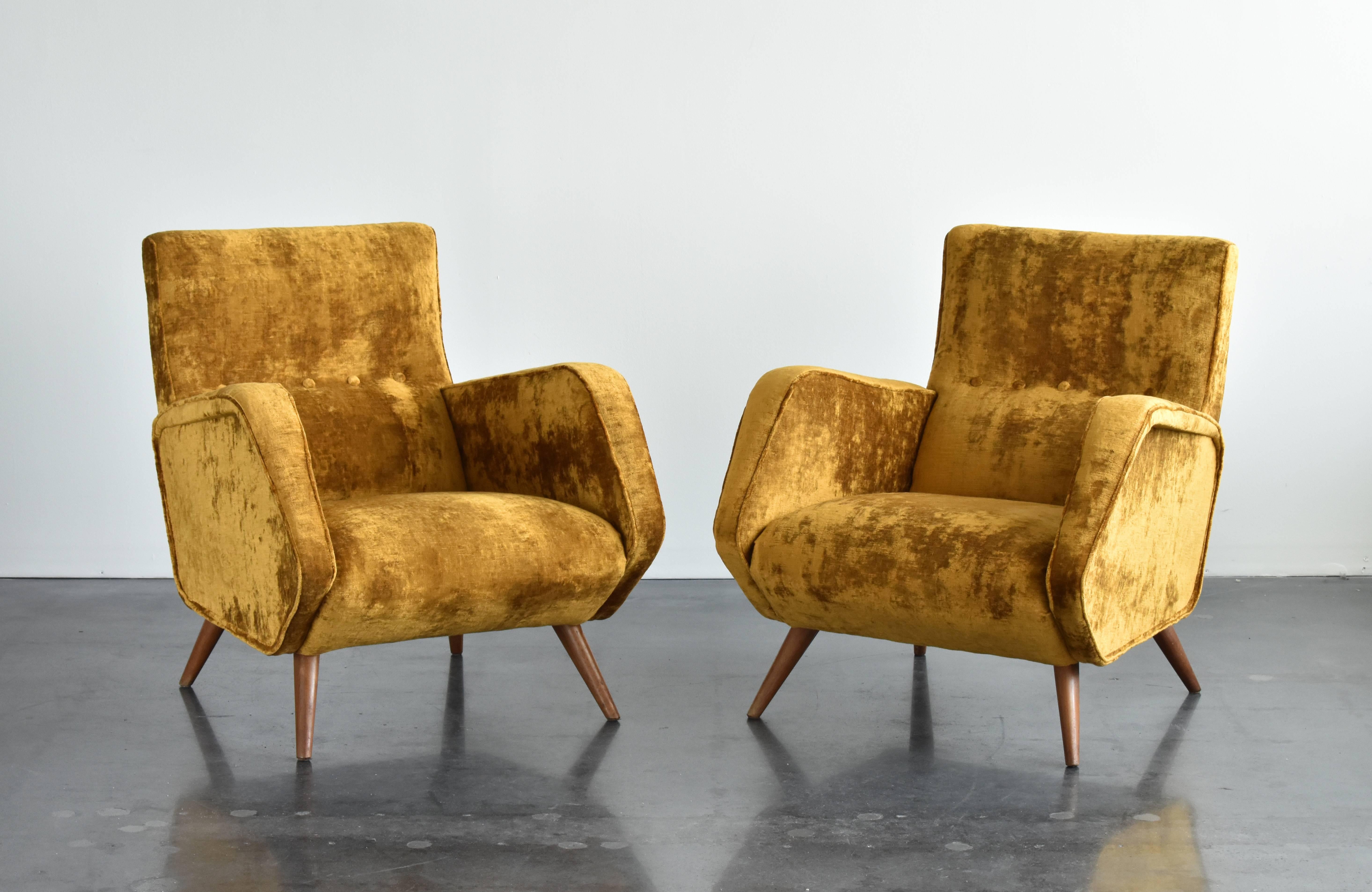 A pair of rare lounge chairs by the Italian architect and designer Osvaldo Borsani. Manufactured by Tecno, in the 1950s. Tapered wooden legs. Reupholstered in a brand new European high-end velvet. Model recorded in the Osvaldo Borsani archives.