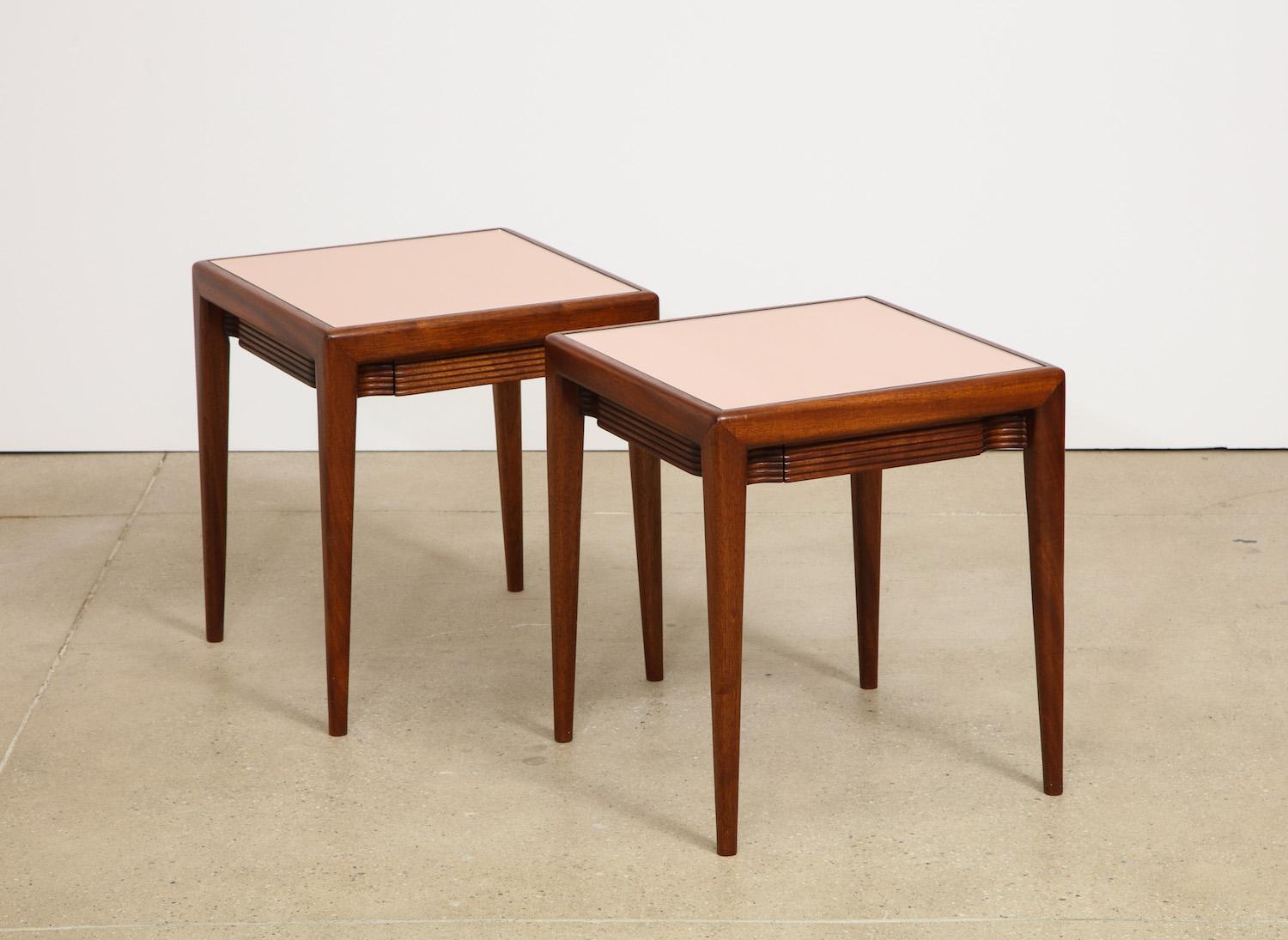 Pair of mirrored-top, low side tables by Osvaldo Borsani. Low square tables of mahogany and inset rose colored mirrored tops with fluted facing on all four sides. One small center drawer per table. A variation of this model lives in the Casa Borsani