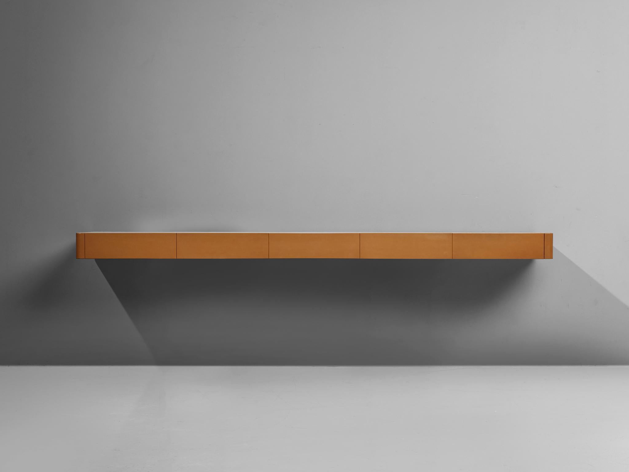 Osvaldo Borsani, M150 wall shelf, wood, leather, Italy, 1967

A wall shelf by the Italian designer Osvaldo Borsani. The design features rounded edges and is upholstered in cognac leather with a wooden tabletop. It has five hidden drawers. Remarkable