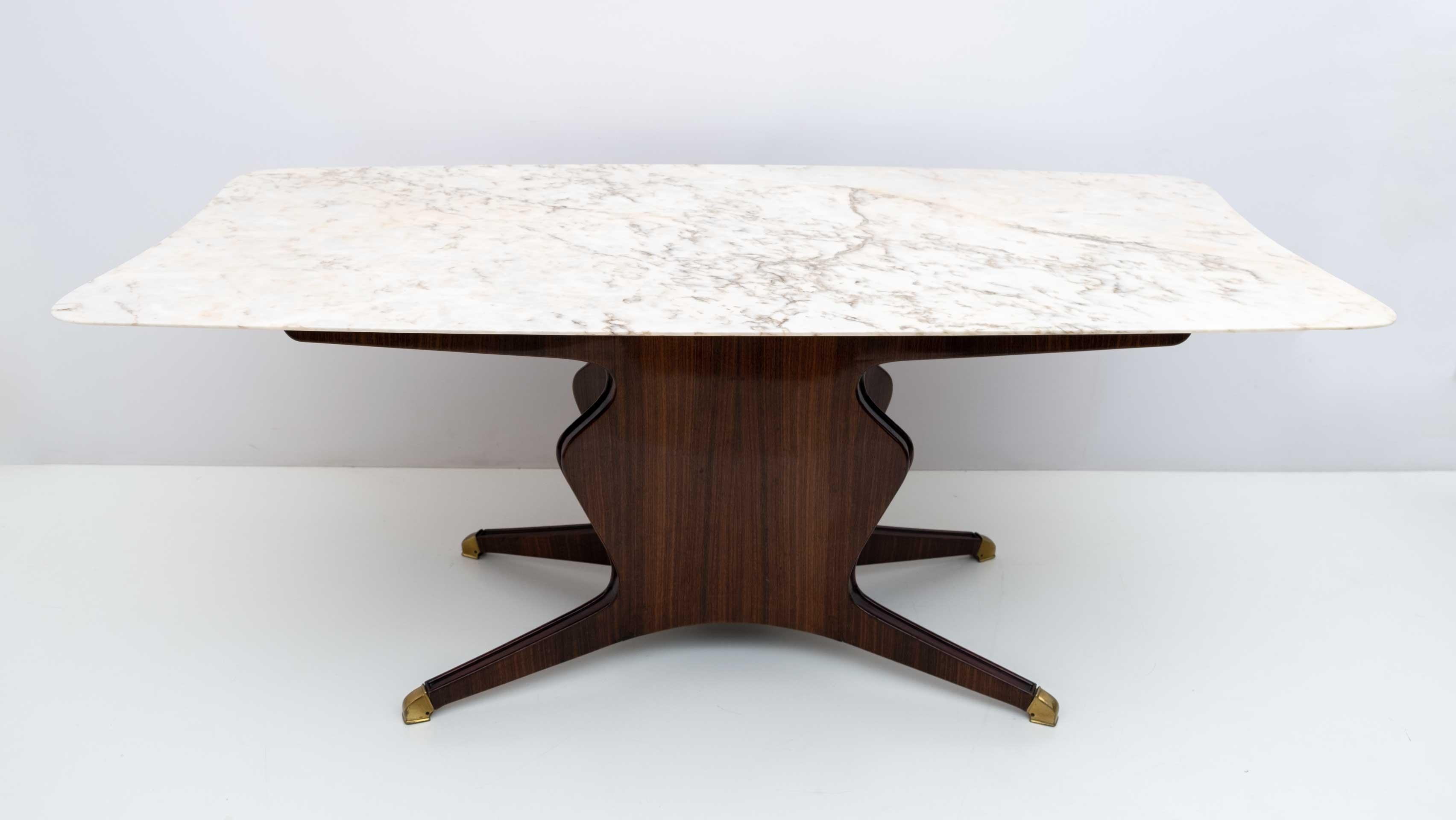 Elegant dining table designed by Osvaldo Borsani, a truly important piece and a great example of 1950s Italian design. Its structure is characterized by a uniquely shaped design, finished with brass feet and equipped with a calacatta marble top with